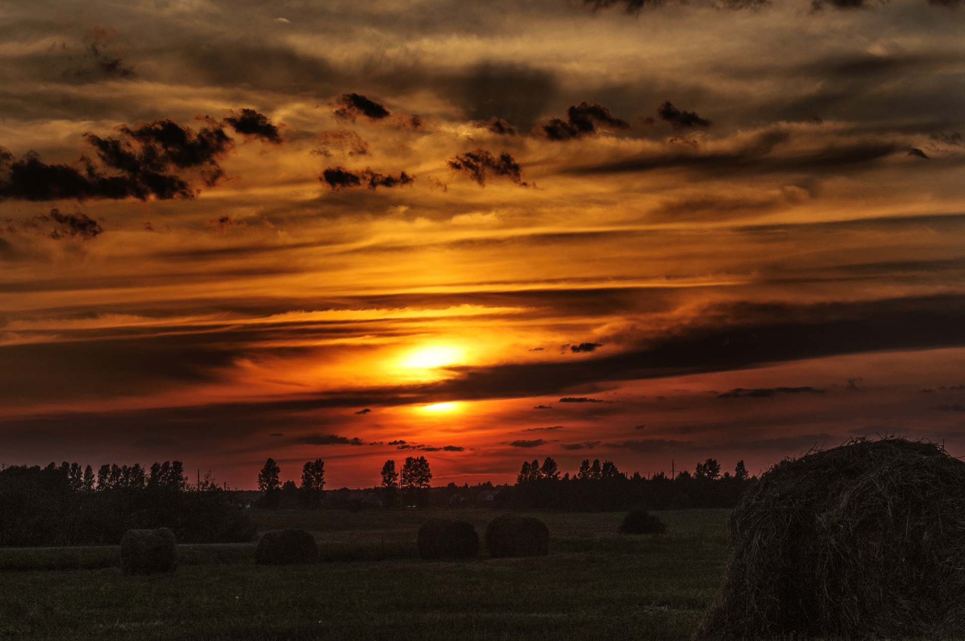 Dramatic Sunset Sky over Field with Hay Bales HD Wallpaper