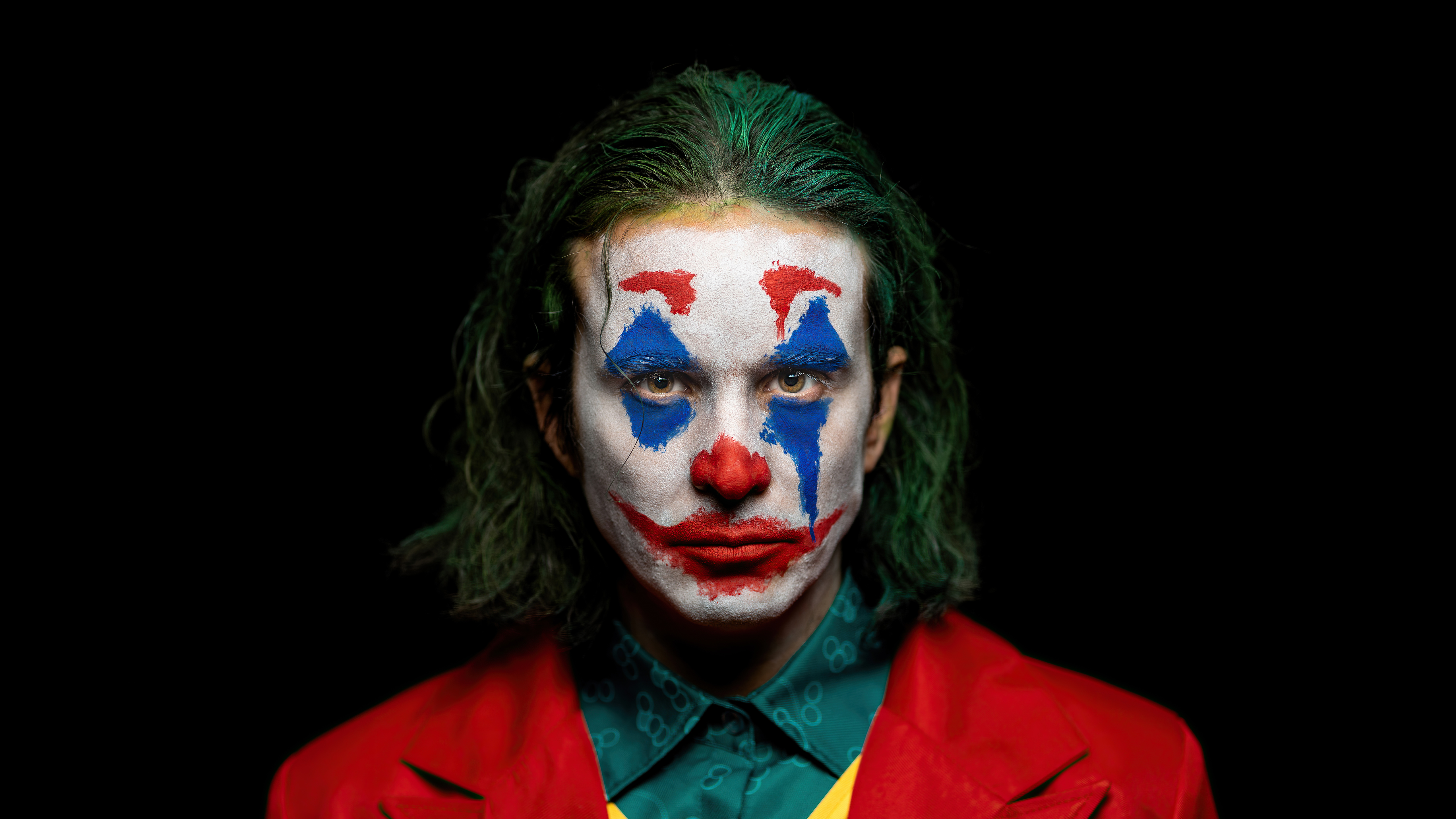 The Joker in his signature clown makeup HD Wallpaper