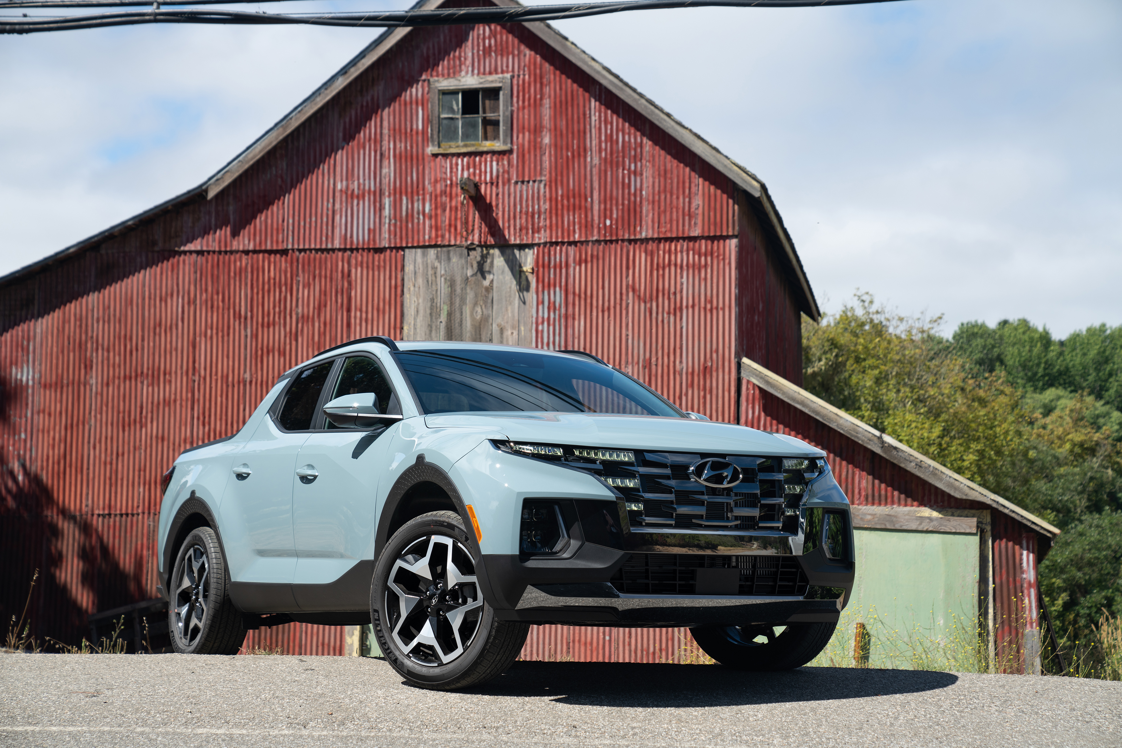 Hyundai Santa Cruz pickup truck in front of a red barn HD Wallpaper