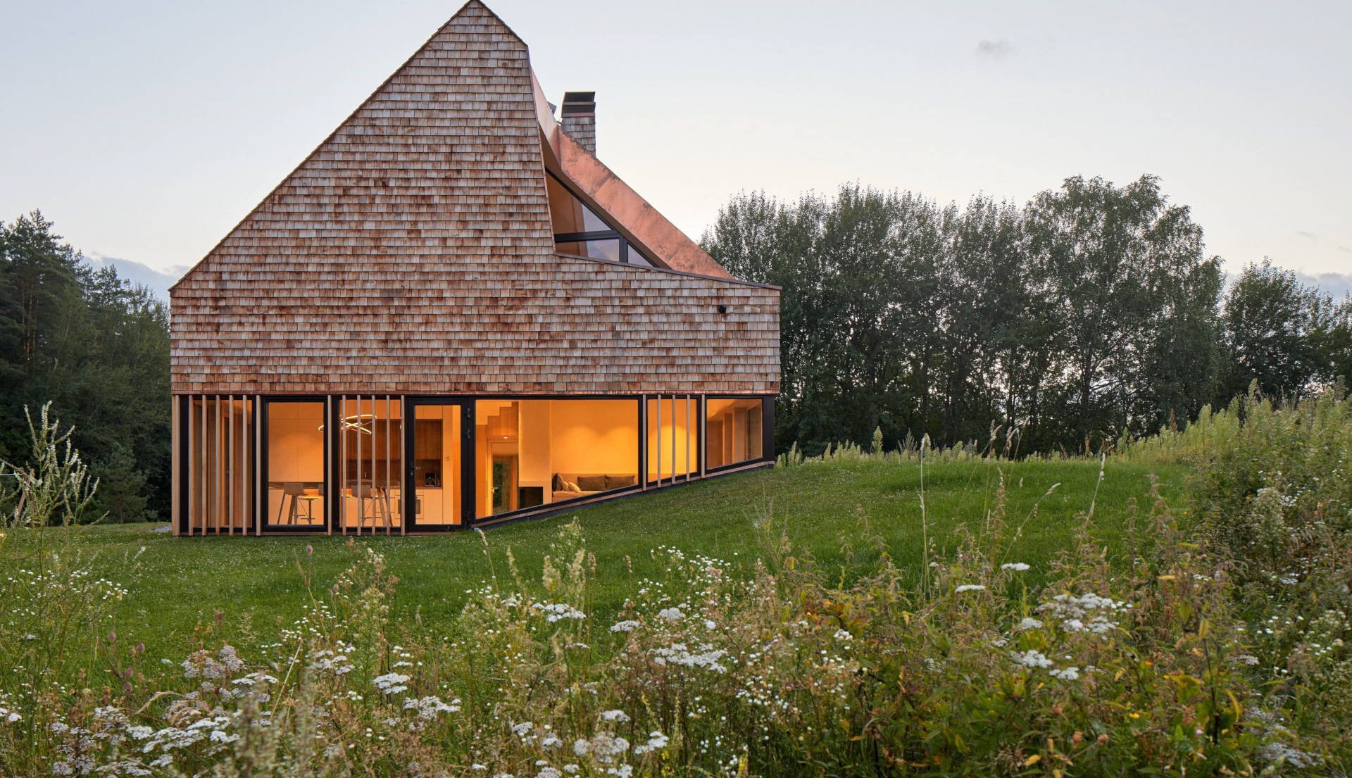 Shingled house with warm glow in a rural field HD Wallpaper