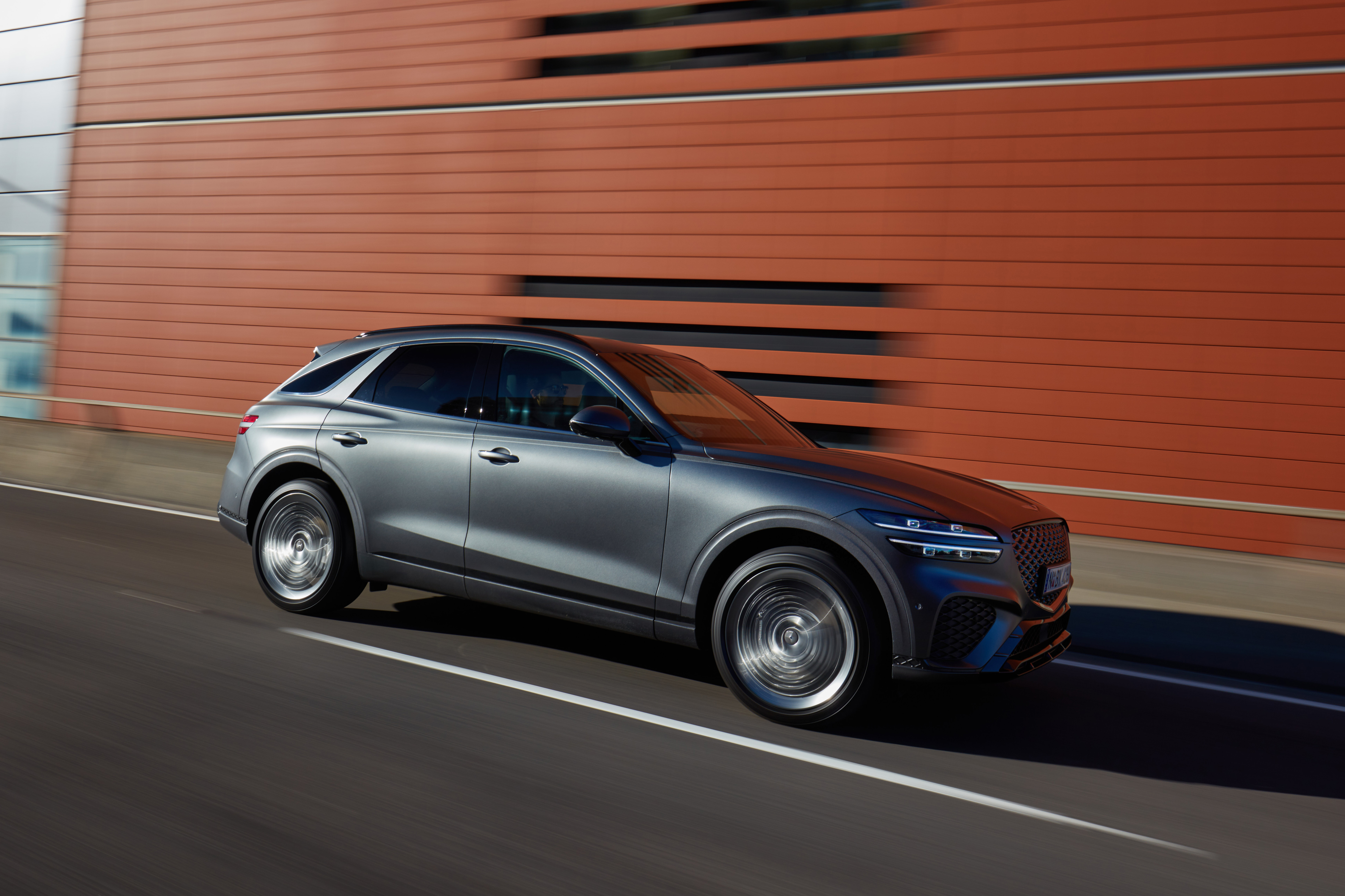 Grey Genesis GV70 SUV in motion HD Wallpaper