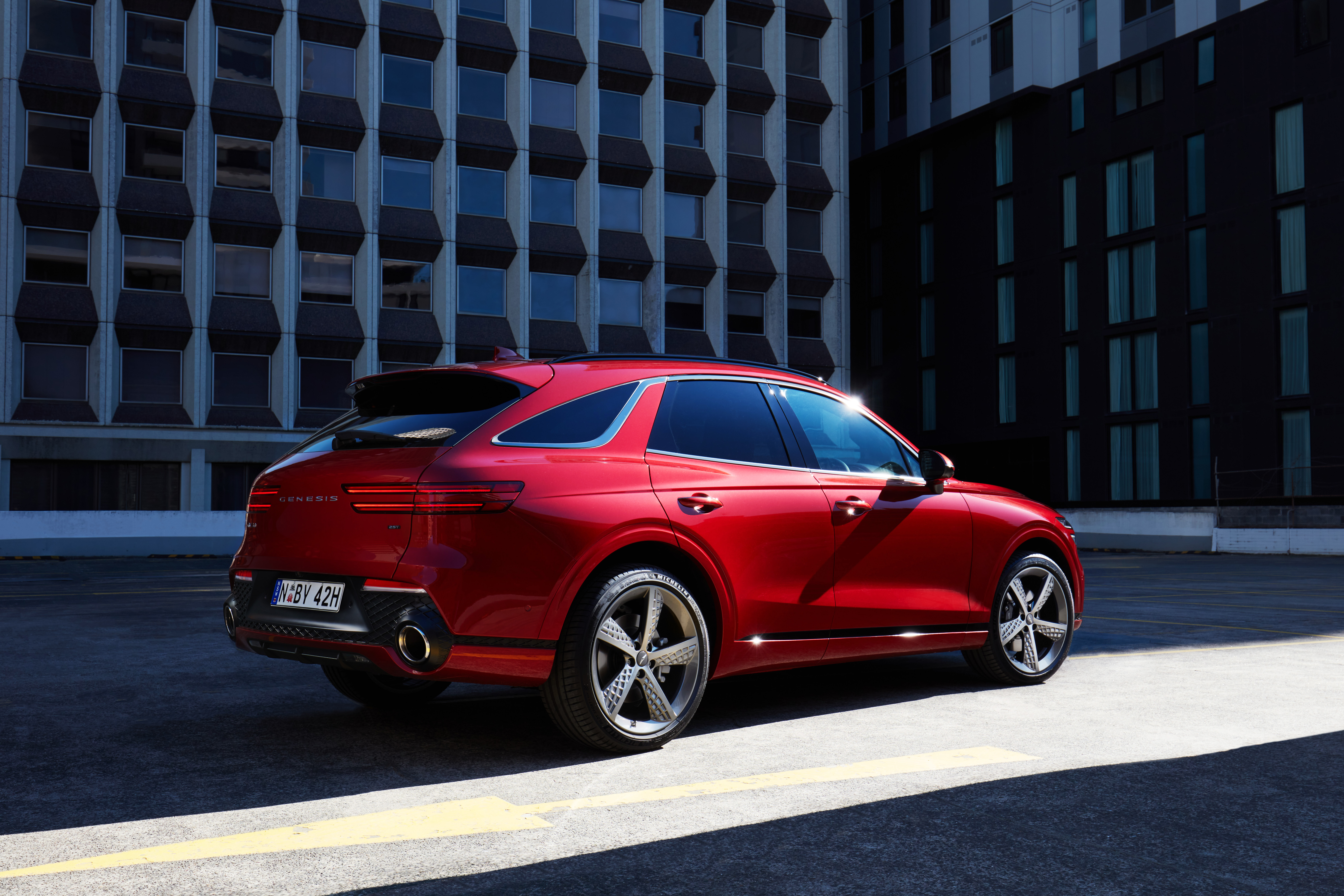 Red Genesis GV70 SUV in urban setting HD Wallpaper