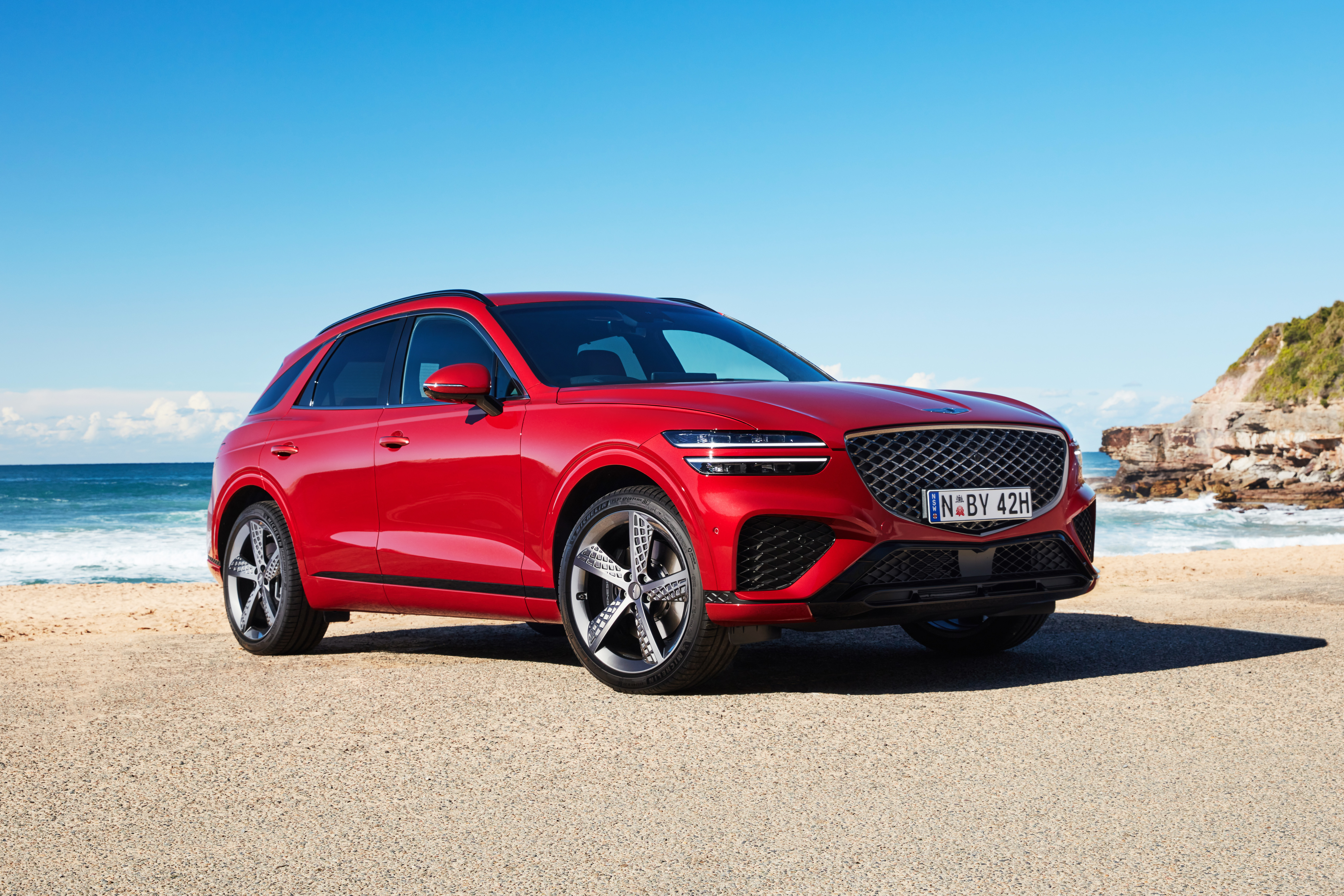 Red Genesis GV70 SUV on a sunny beach HD Wallpaper