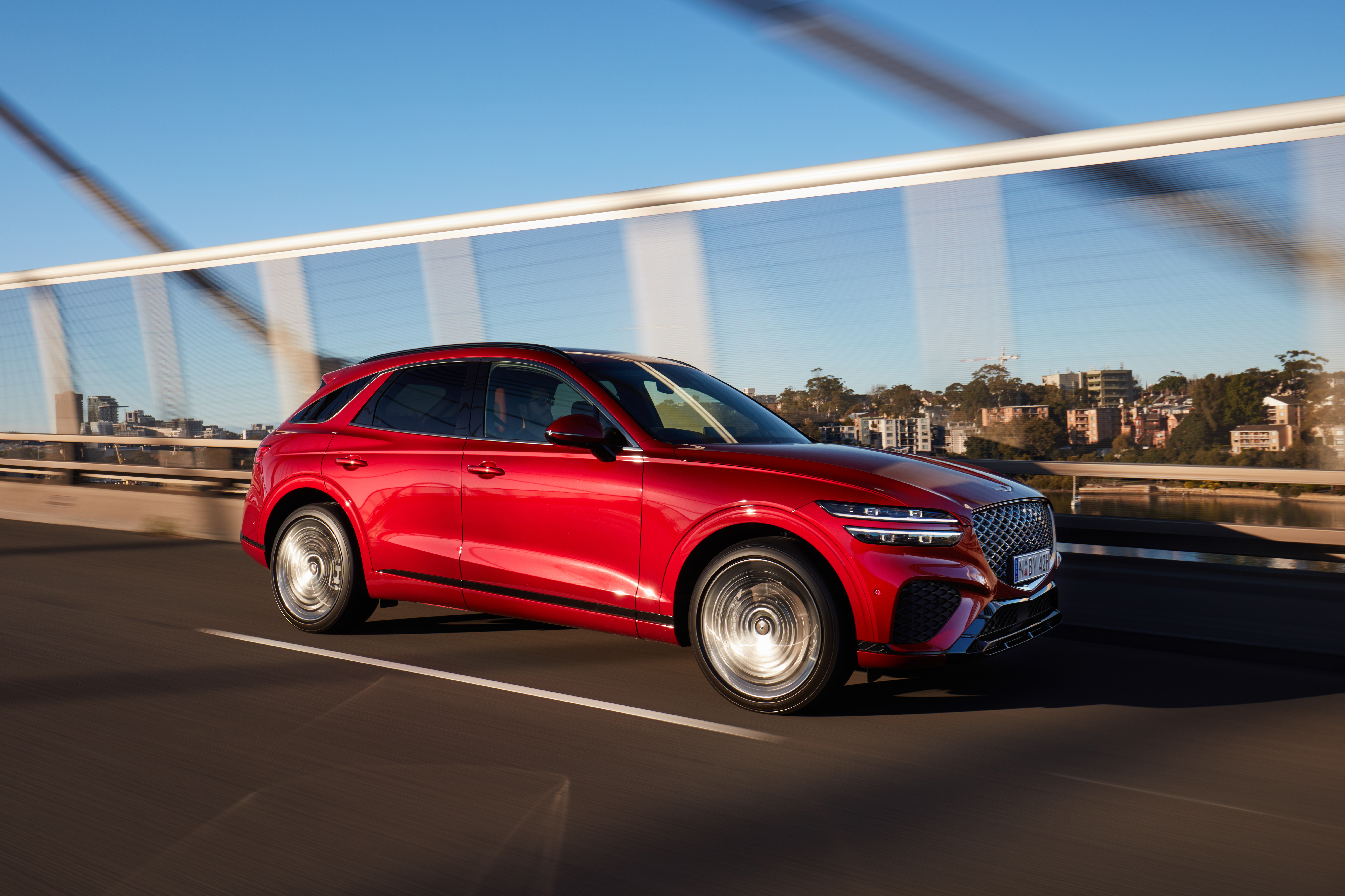 Red Genesis GV70 SUV driving on a bridge HD Wallpaper