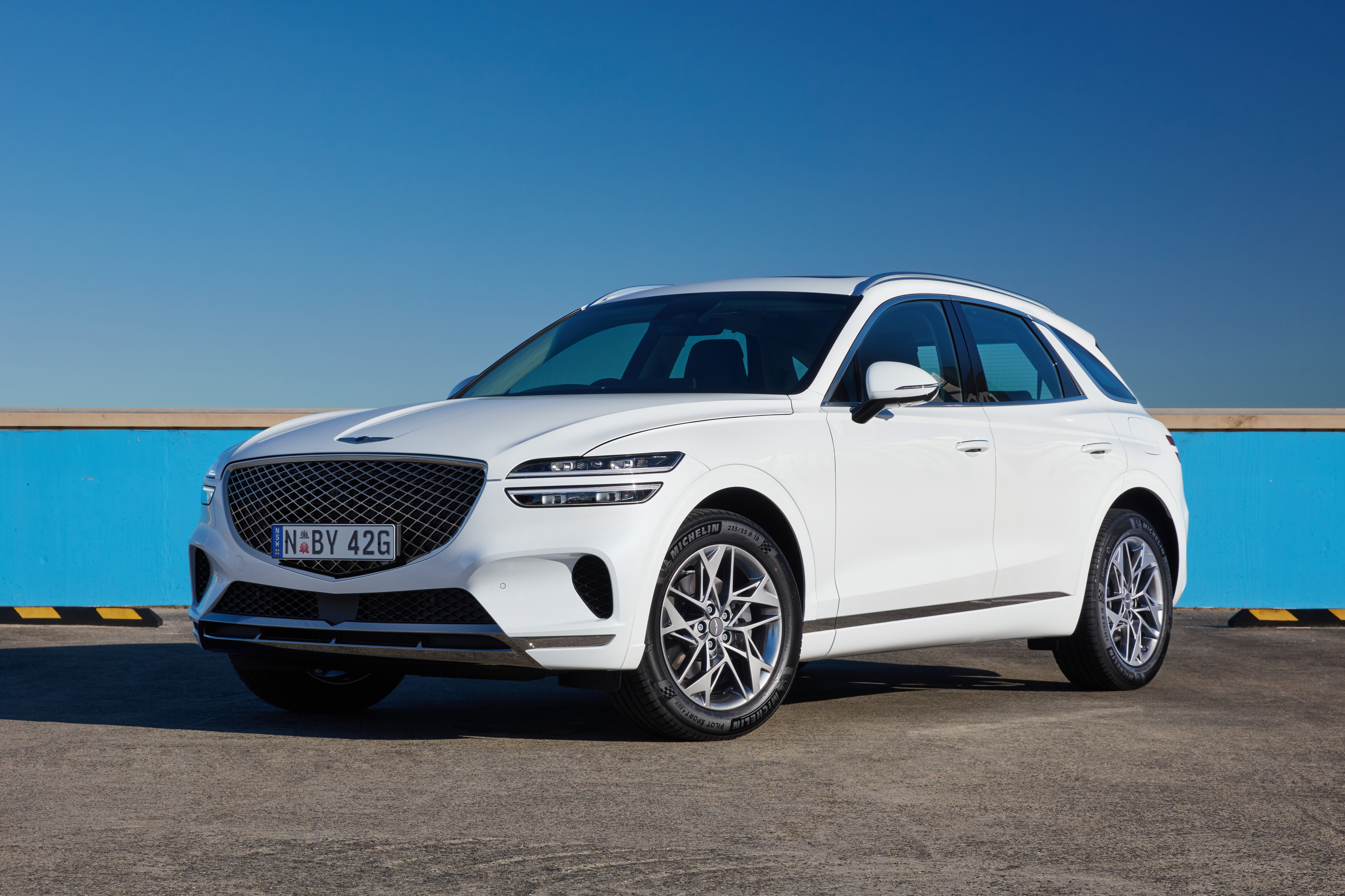 White Genesis GV70 2.5T SUV parked outdoors HD Wallpaper
