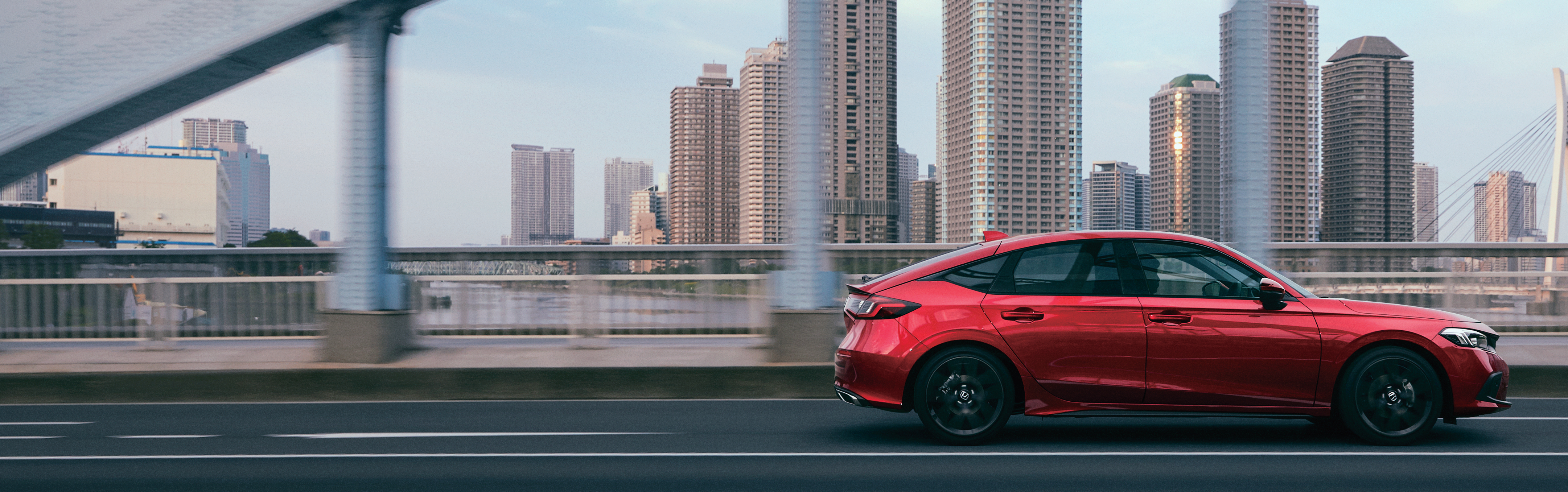 Red Honda Civic Hatchback driving on a city bridge HD Wallpaper