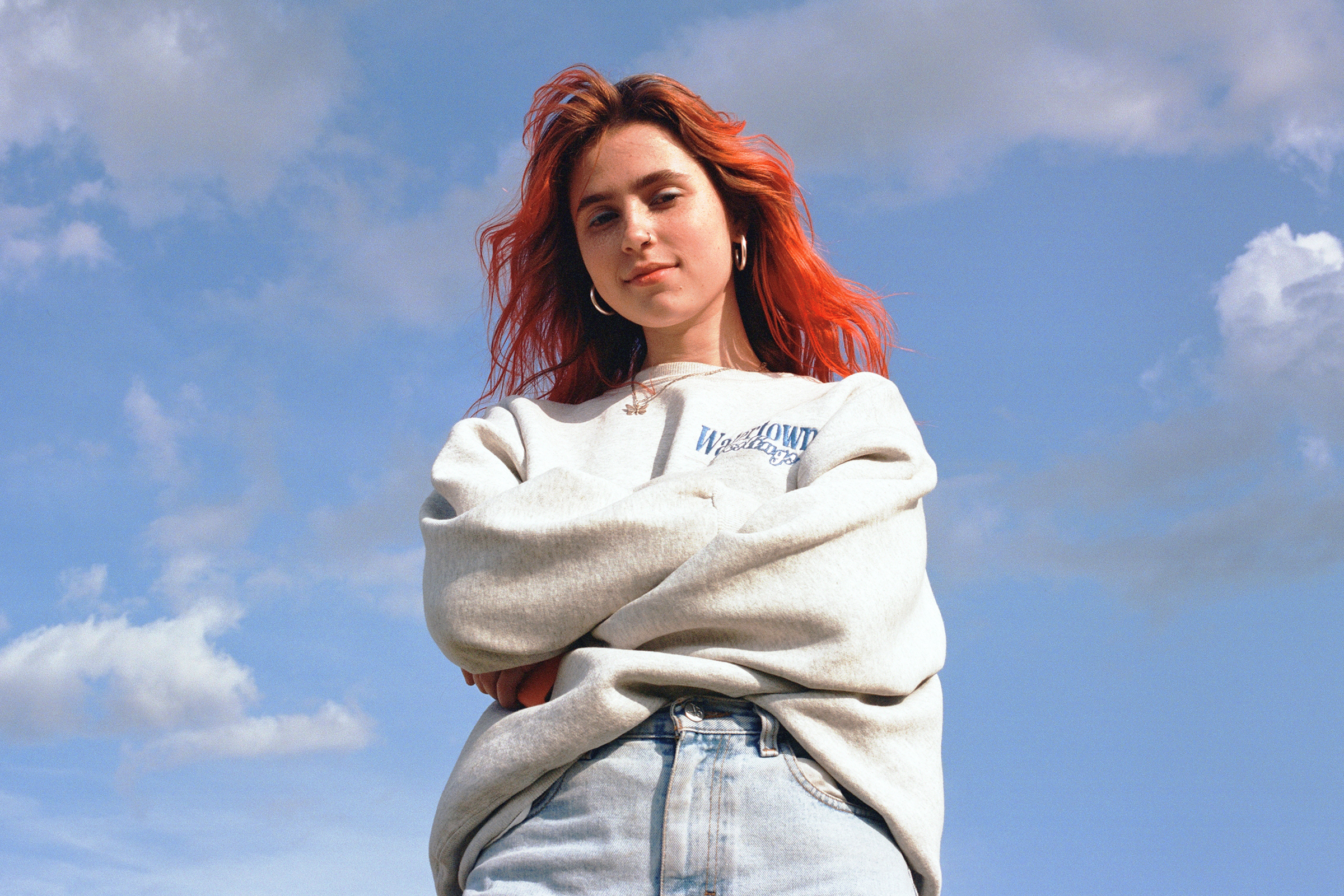 Clairo with red hair against a blue sky HD Wallpaper