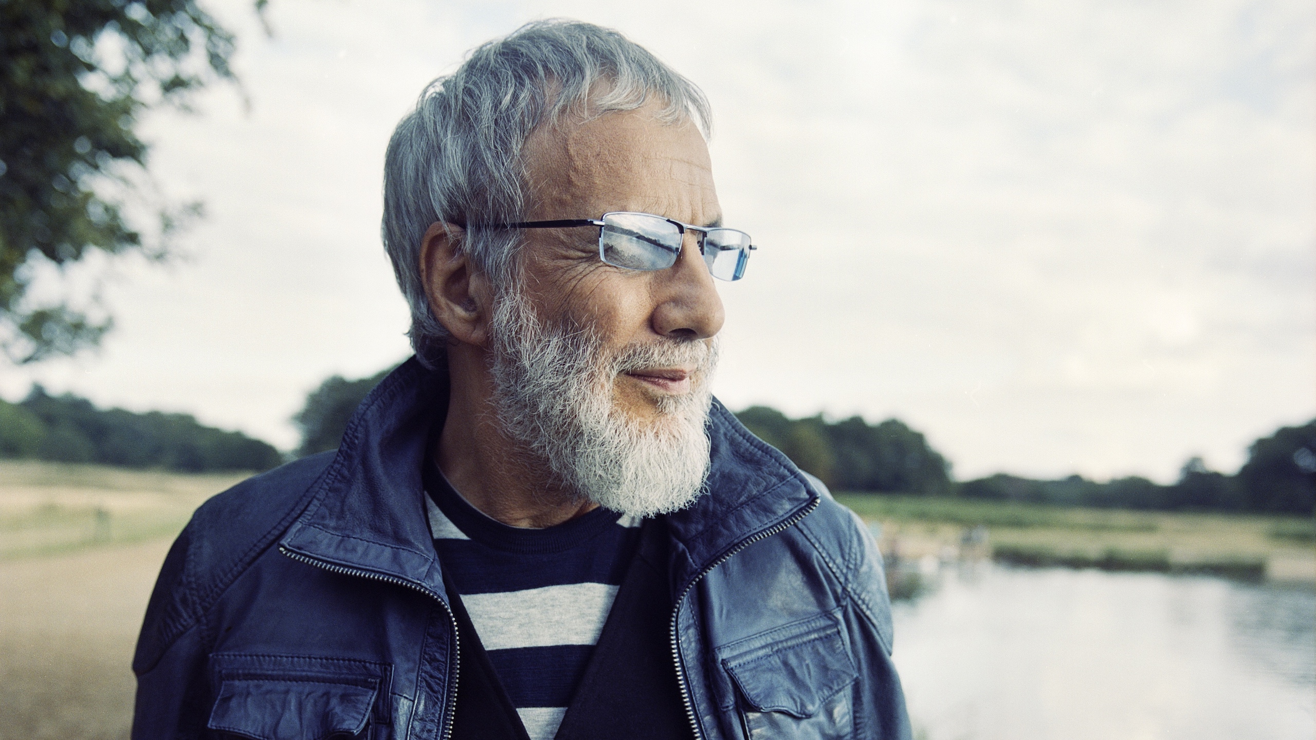 Cat Stevens outdoors with beard and glasses HD Wallpaper