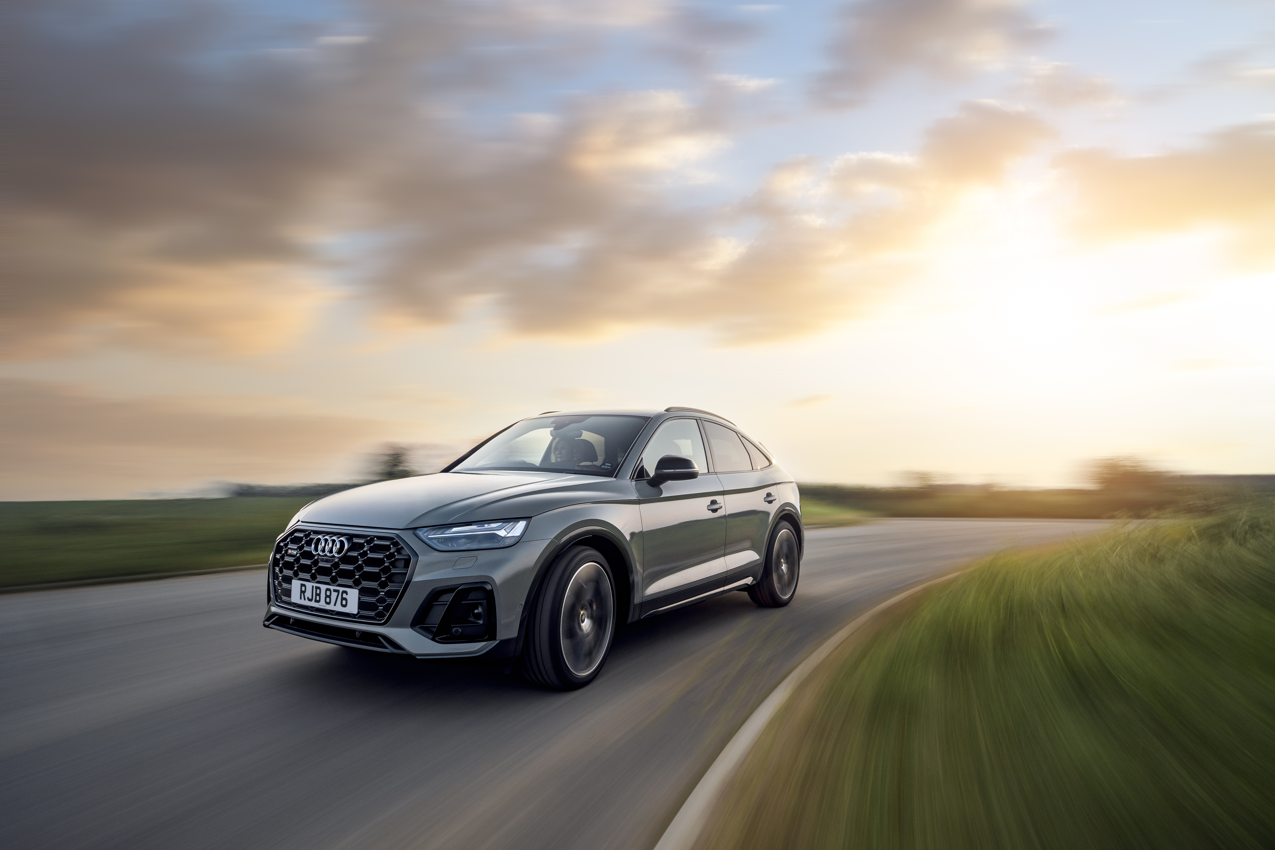 Grey Audi SQ5 Sportback speeding on a country road at sunset HD Wallpaper