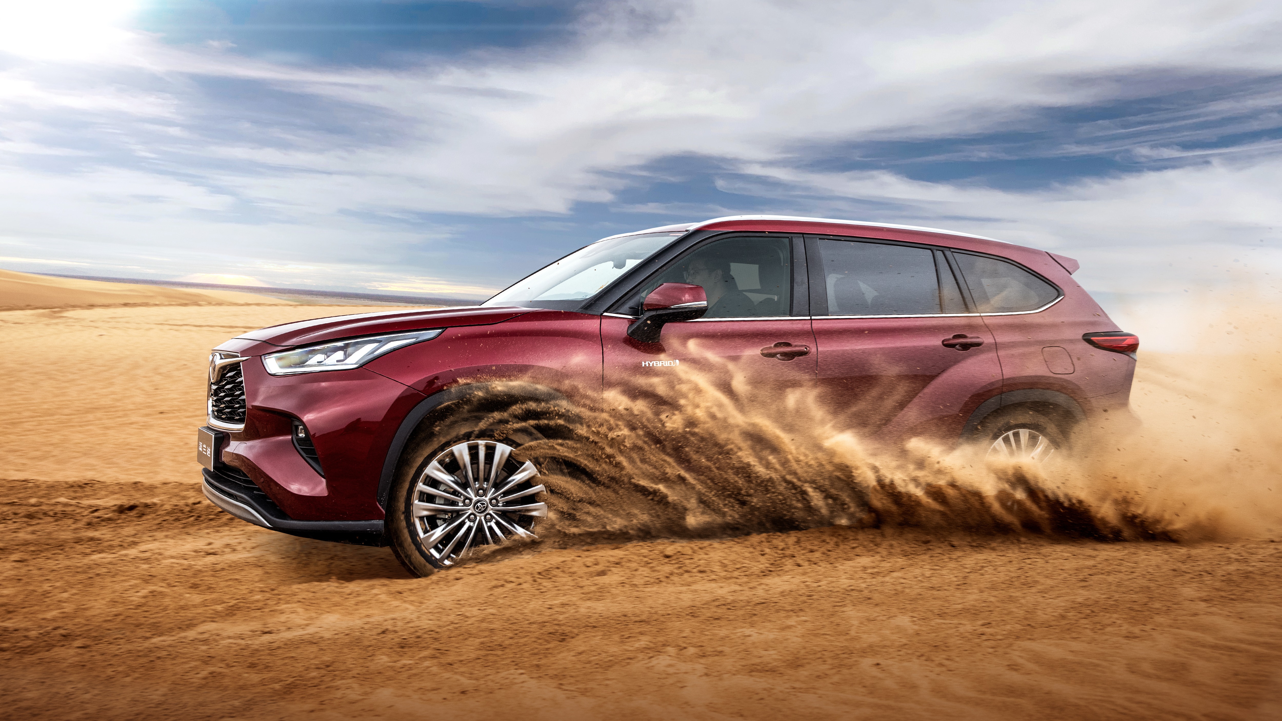 Dynamic Toyota Highlander Hybrid SUV driving through desert sand HD Wallpaper
