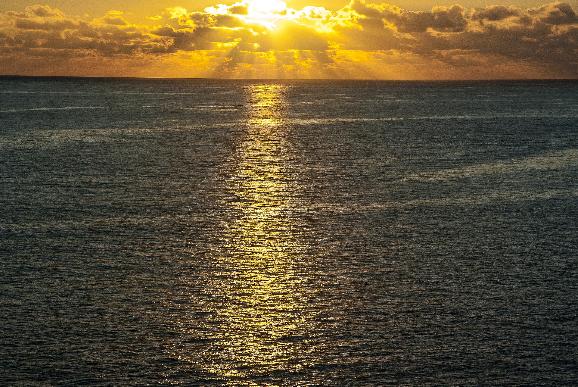 Ocean sunset with dramatic sun rays and golden glow HD Wallpaper