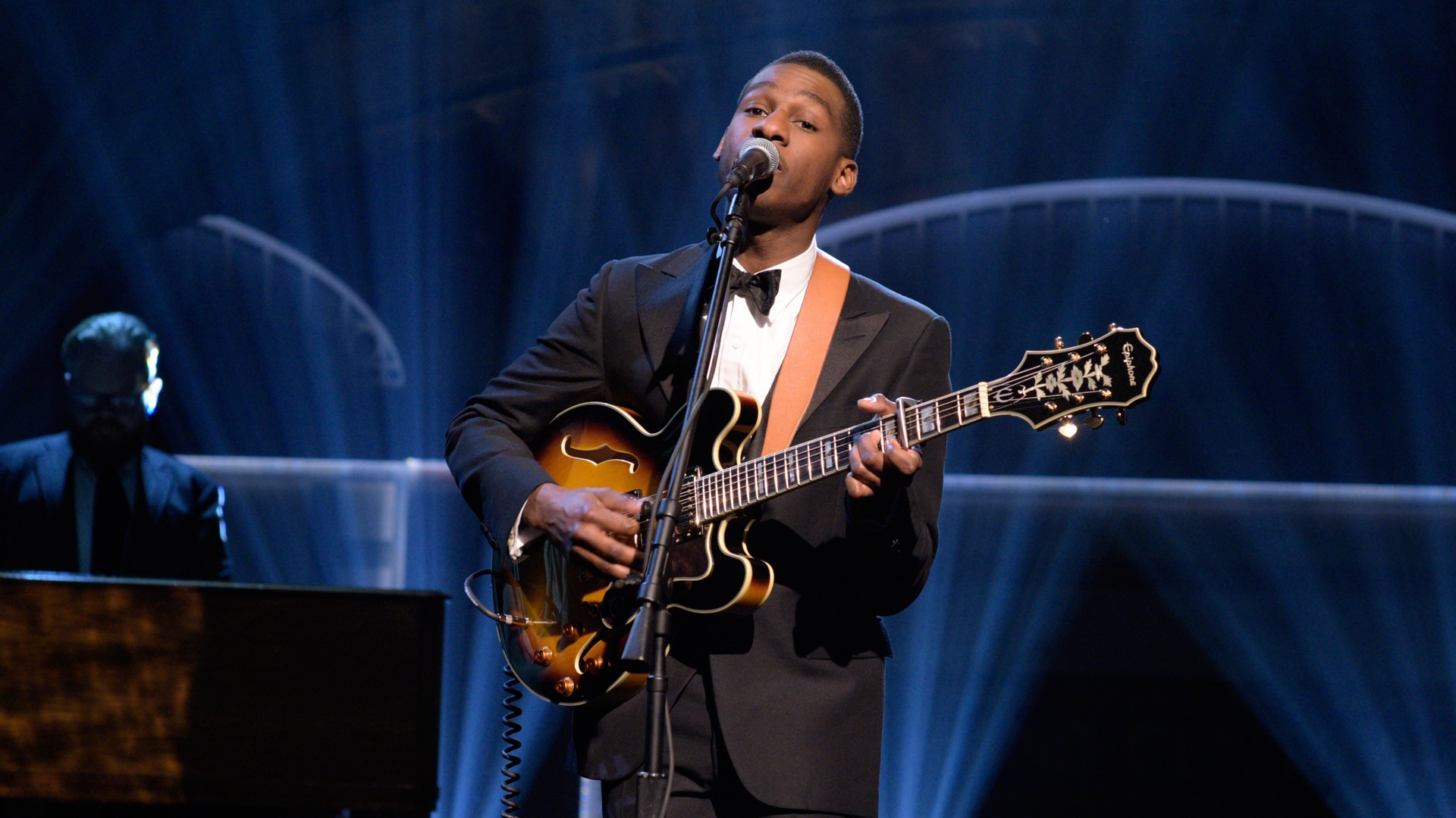 Leon Bridges performing live on stage with guitar HD Wallpaper