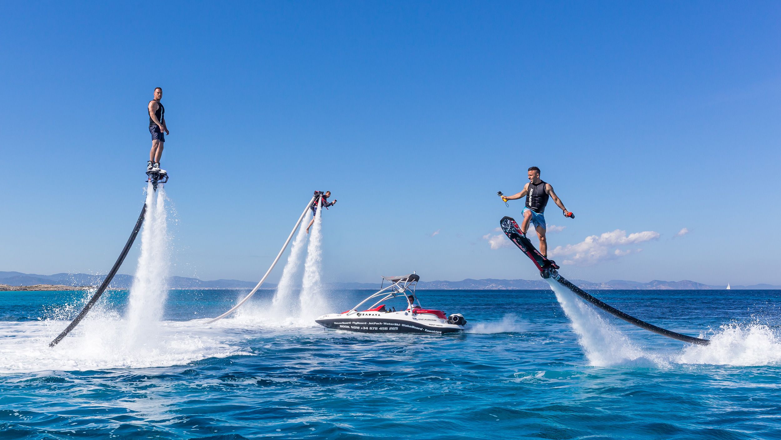 Multiple people enjoying flyboarding in the ocean HD Wallpaper