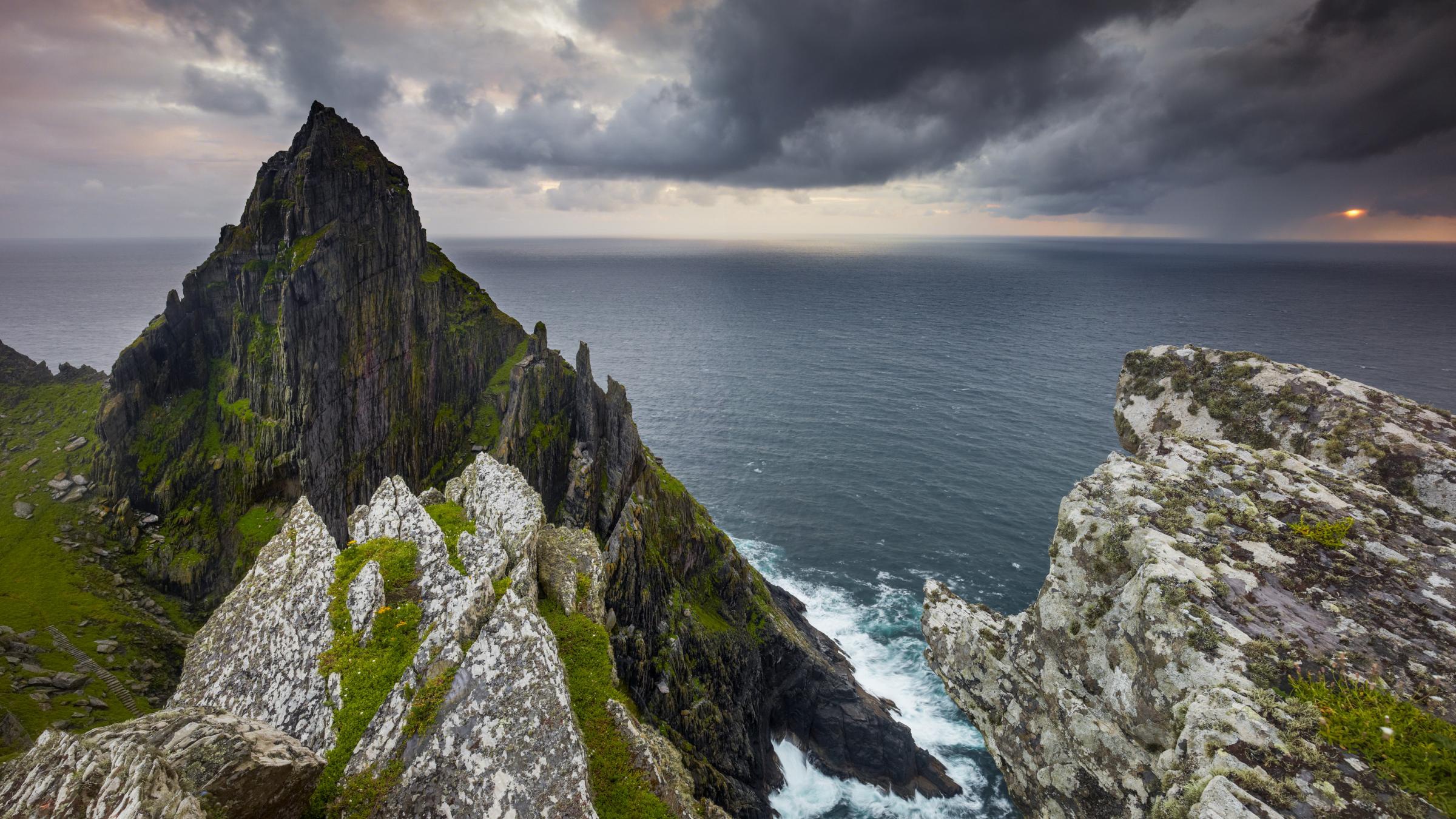 Dramatic Rugged Coastline with Craggy Peaks and Stormy Sky HD Wallpaper