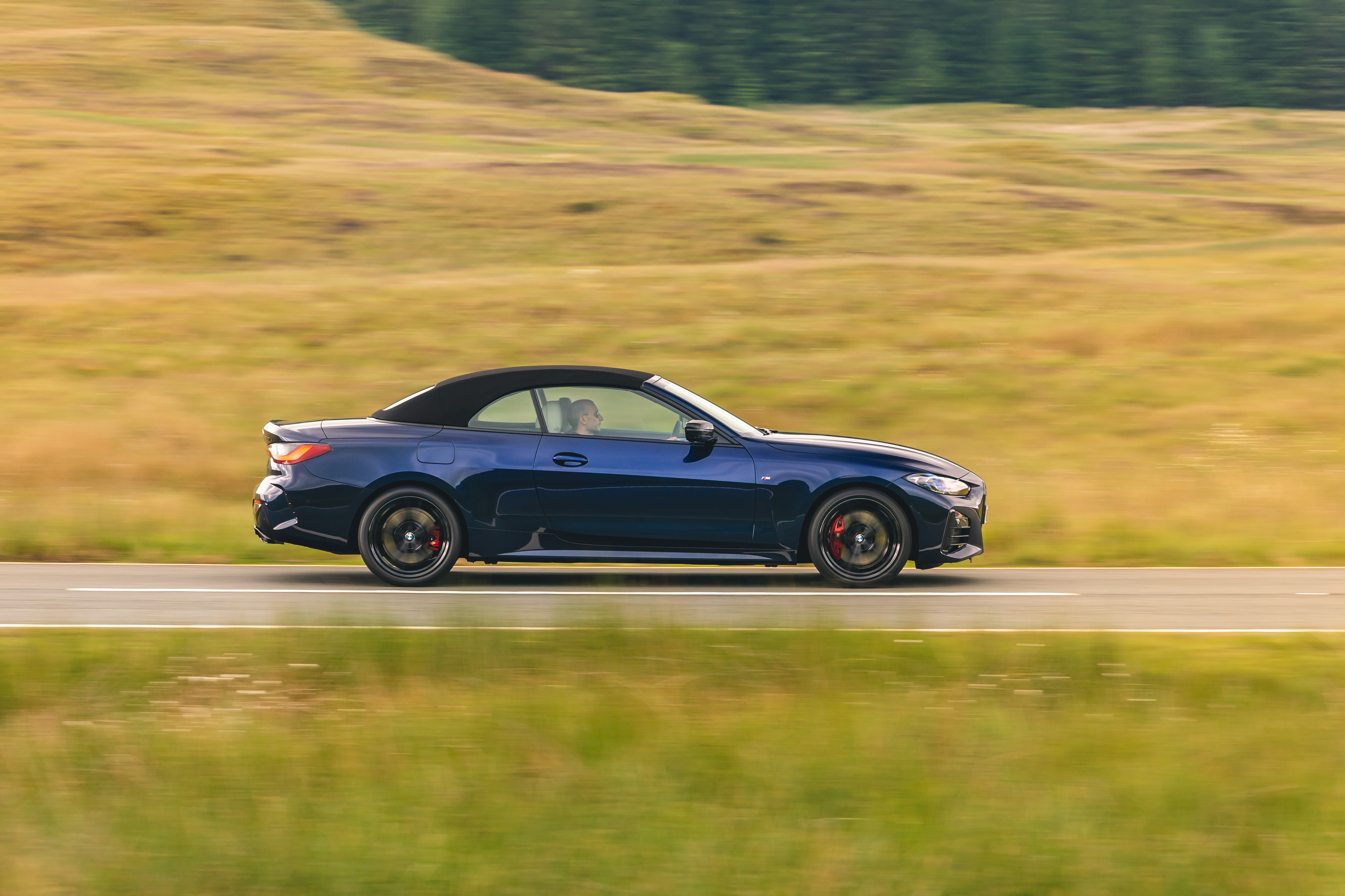 Blue BMW M440i Cabriolet driving on a scenic road HD Wallpaper
