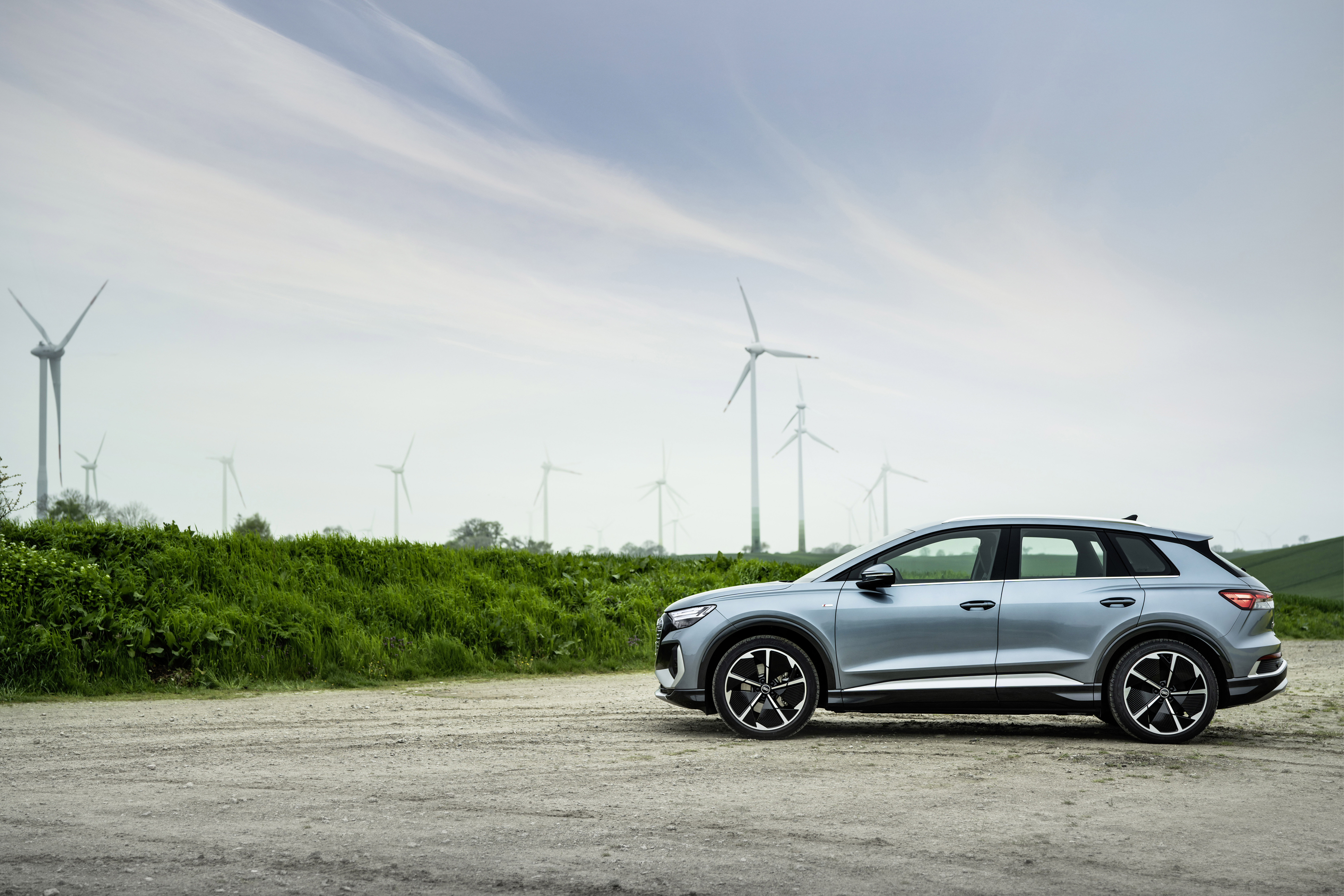 Audi Q4 e-tron electric SUV with wind turbines HD Wallpaper