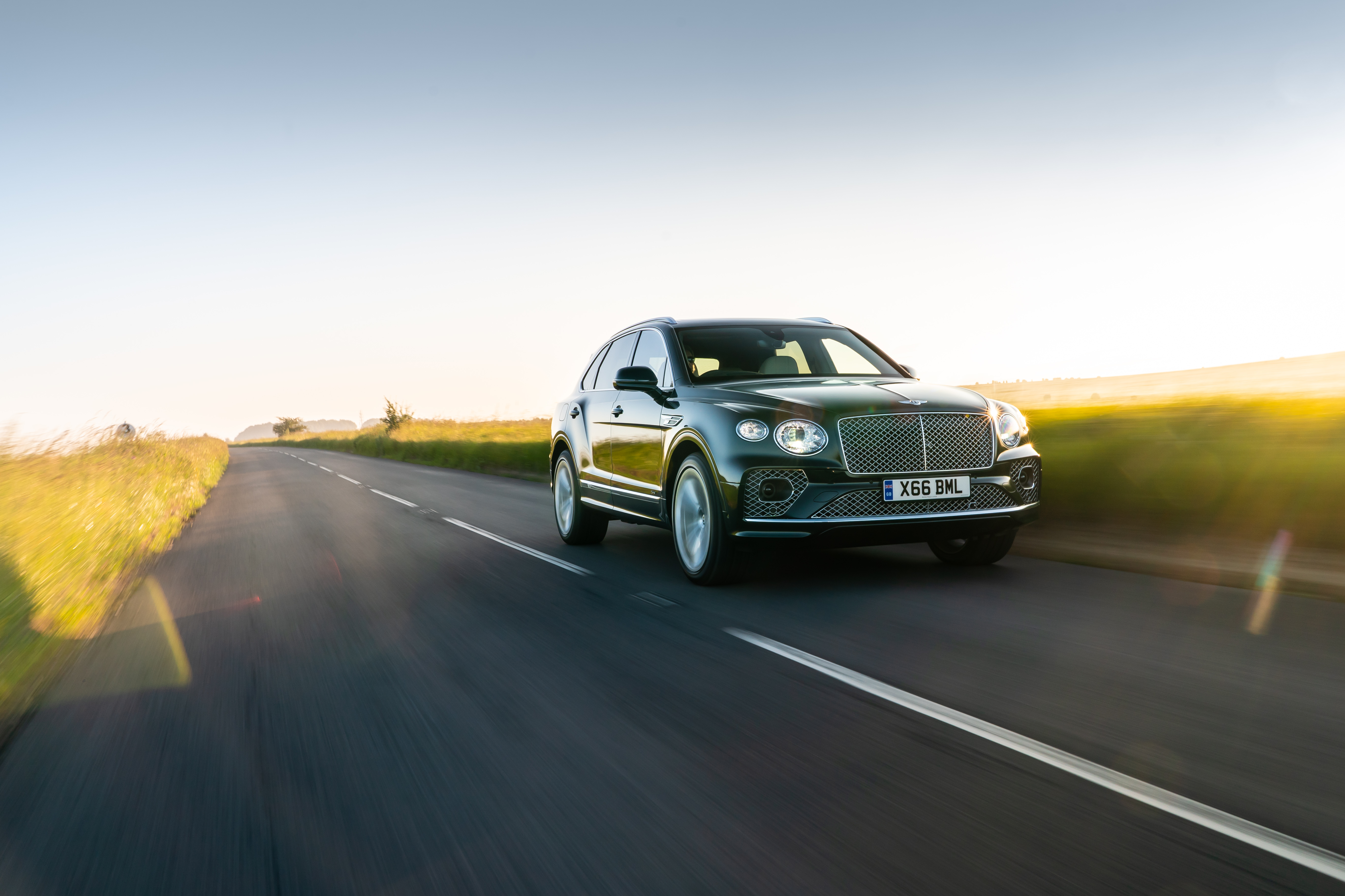 Bentley Bentayga Hybrid SUV on a golden hour drive HD Wallpaper