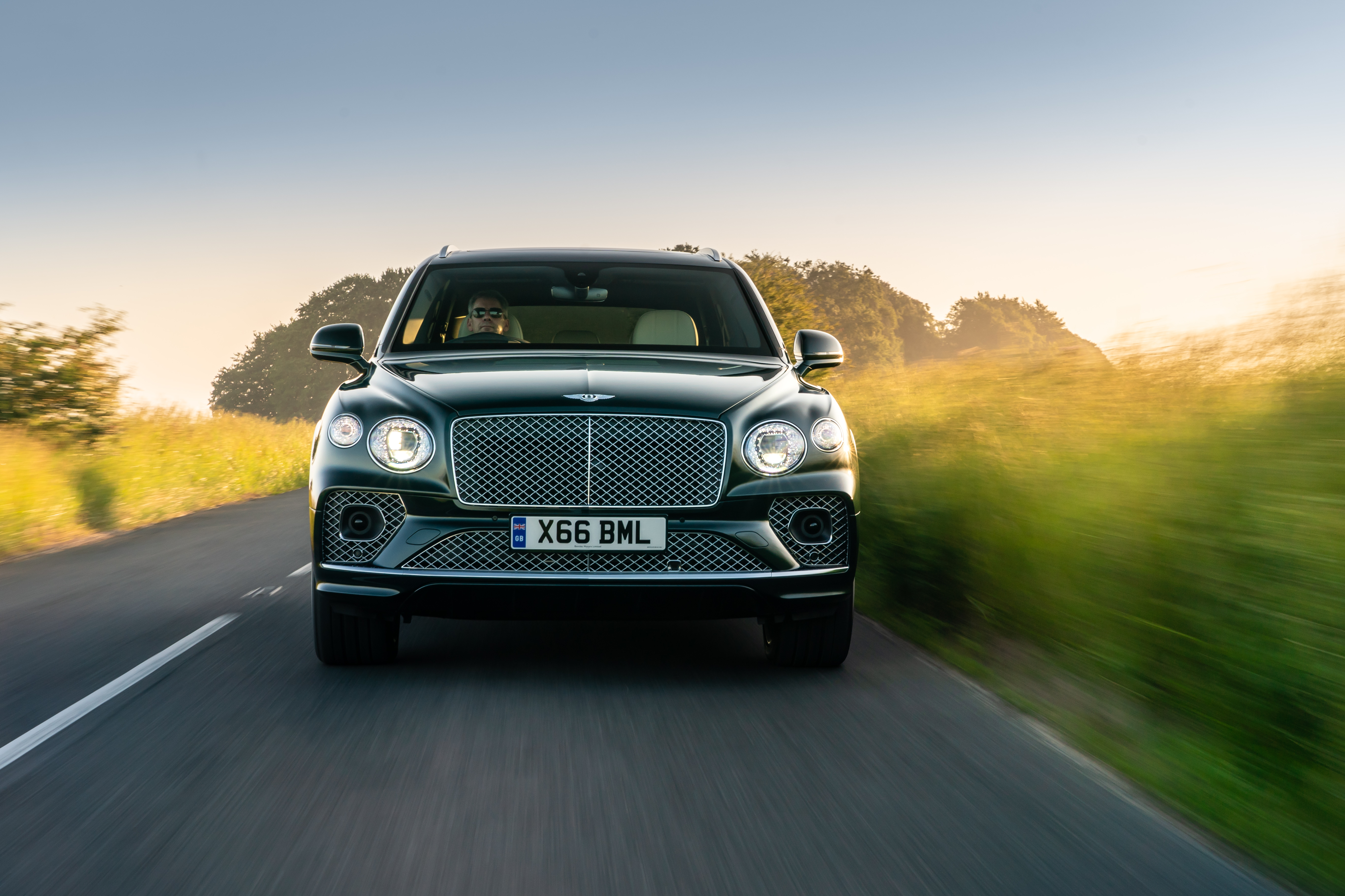 Bentley Bentayga Hybrid SUV driving at golden hour HD Wallpaper