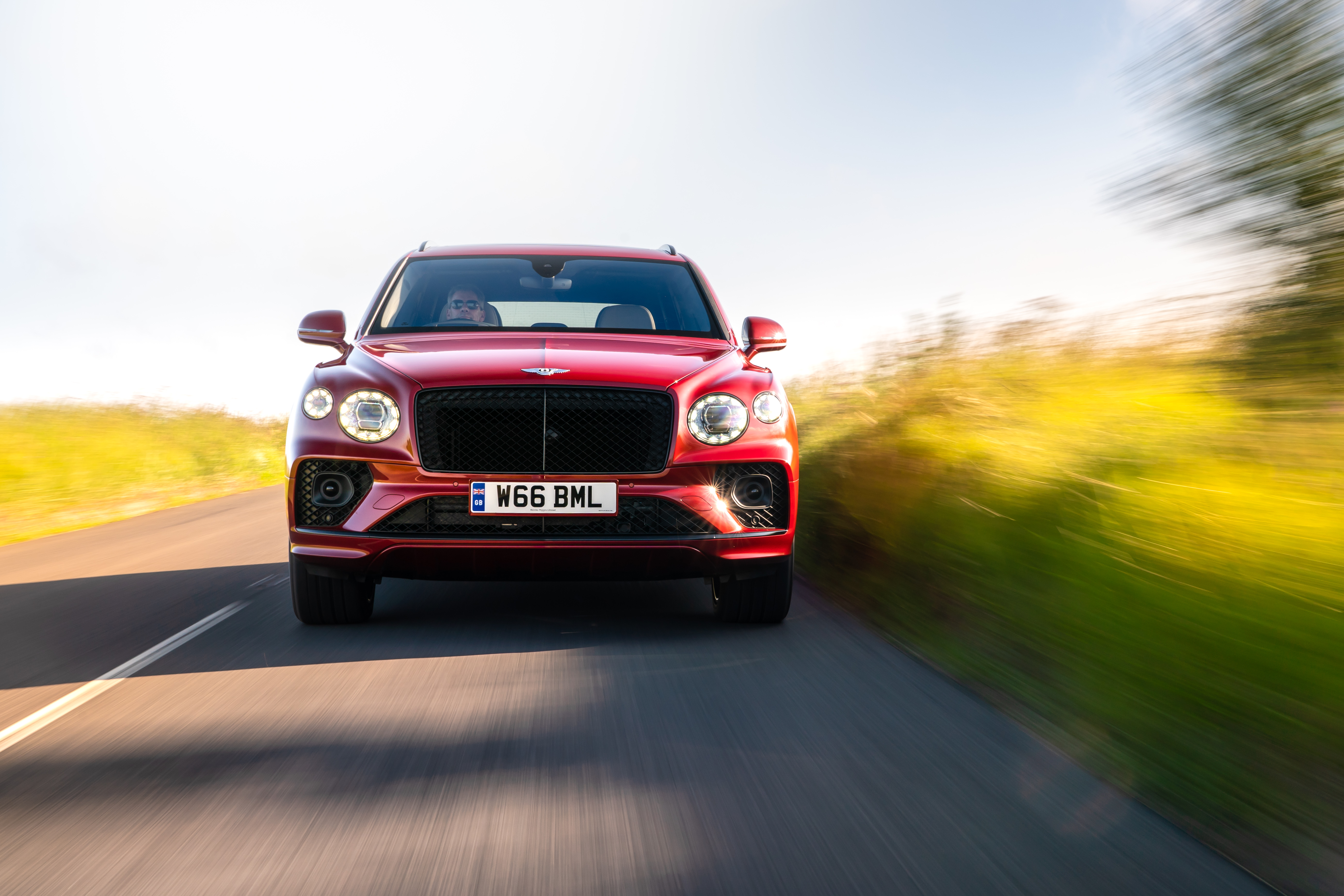 Red Bentley Bentayga Hybrid SUV in motion HD Wallpaper