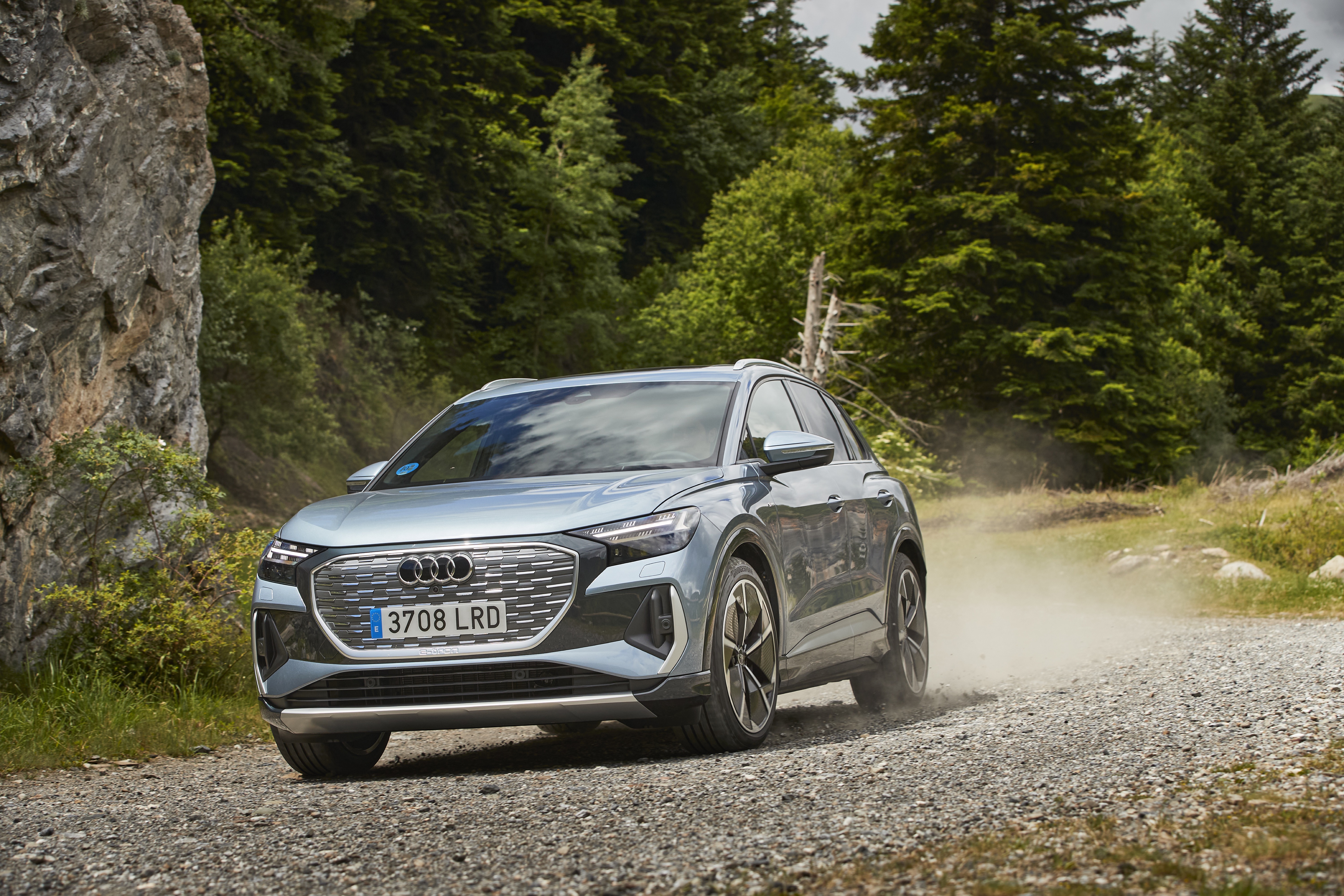 Audi Q4 e-tron electric SUV on dusty gravel road HD Wallpaper