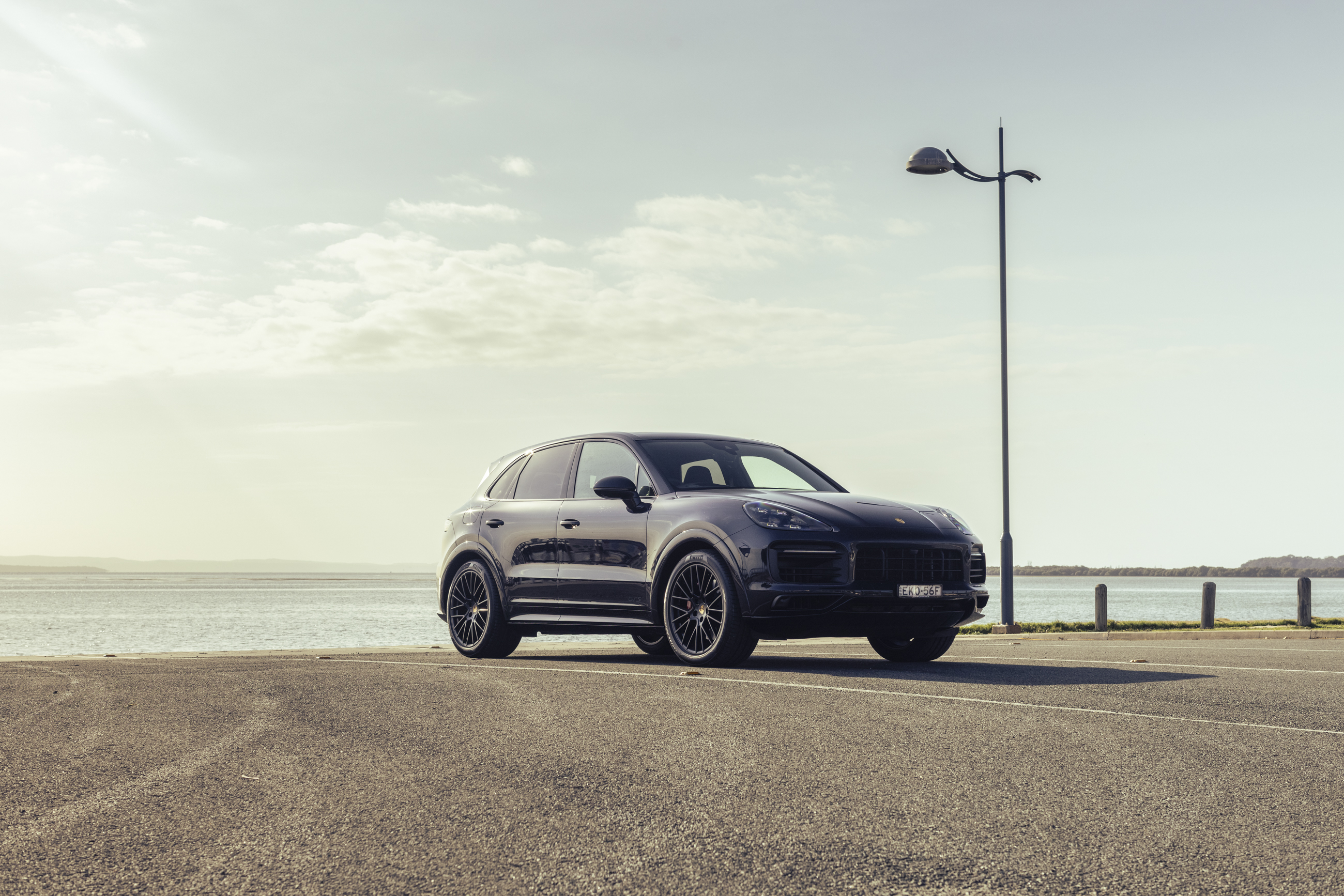 Black Porsche Cayenne GTS SUV parked by the water HD Wallpaper