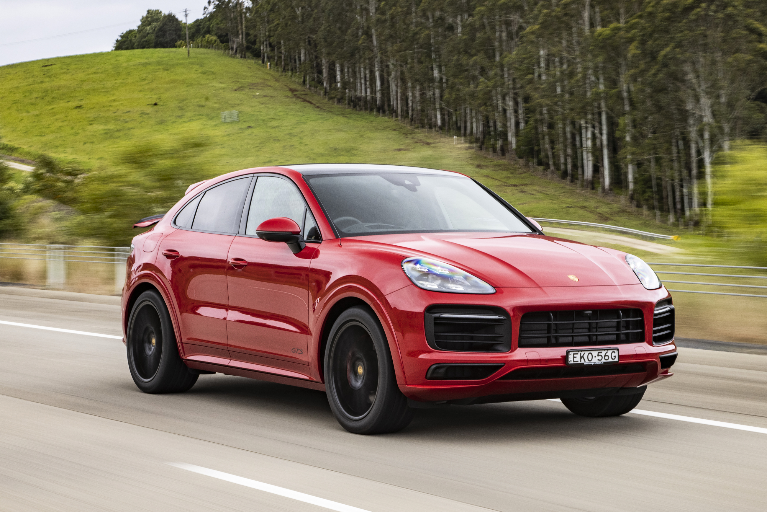 Luxury Red Porsche Cayenne GTS Coupé SUV driving on road HD Wallpaper