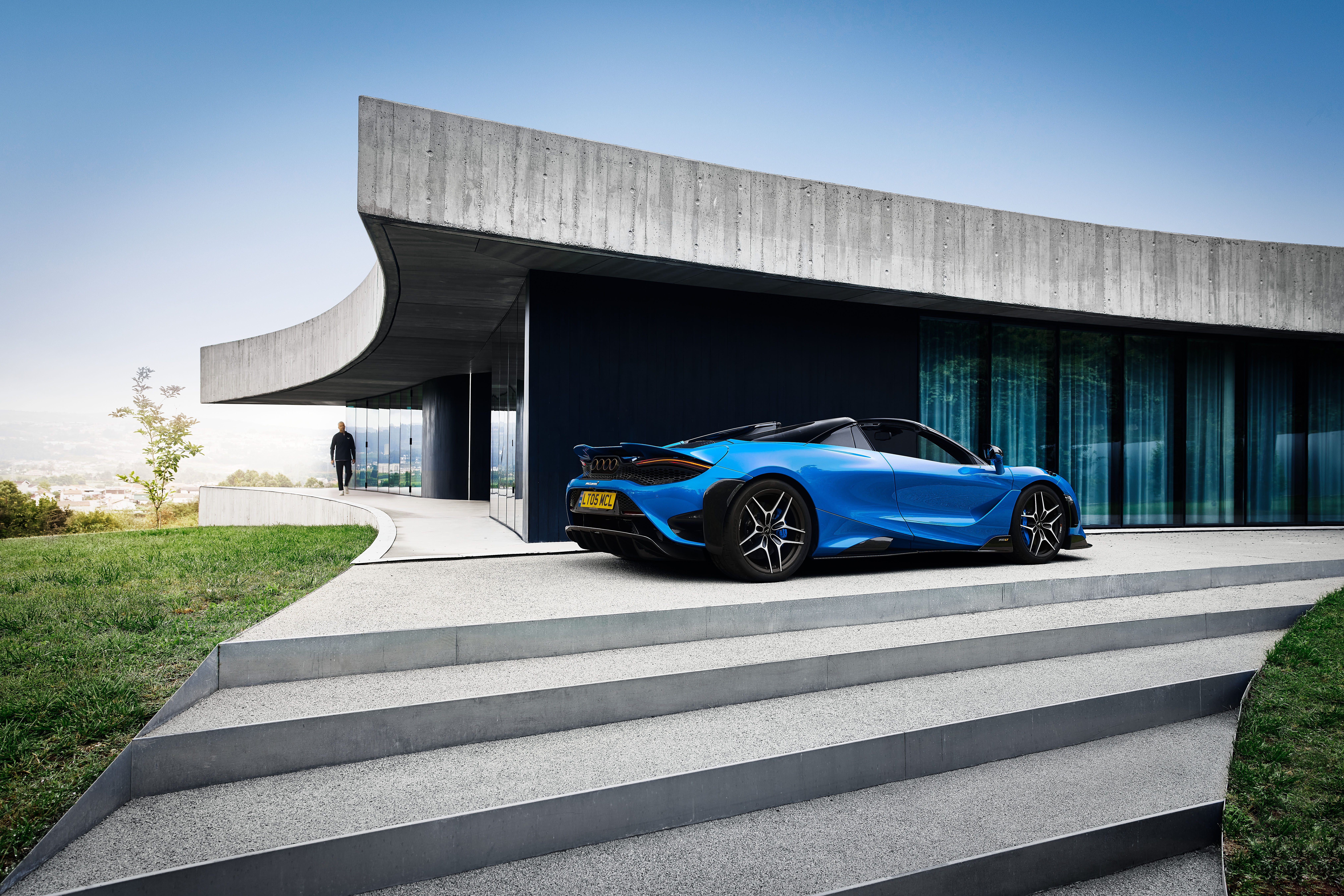 McLaren 765LT Spider parked outside a luxury modern home HD Wallpaper