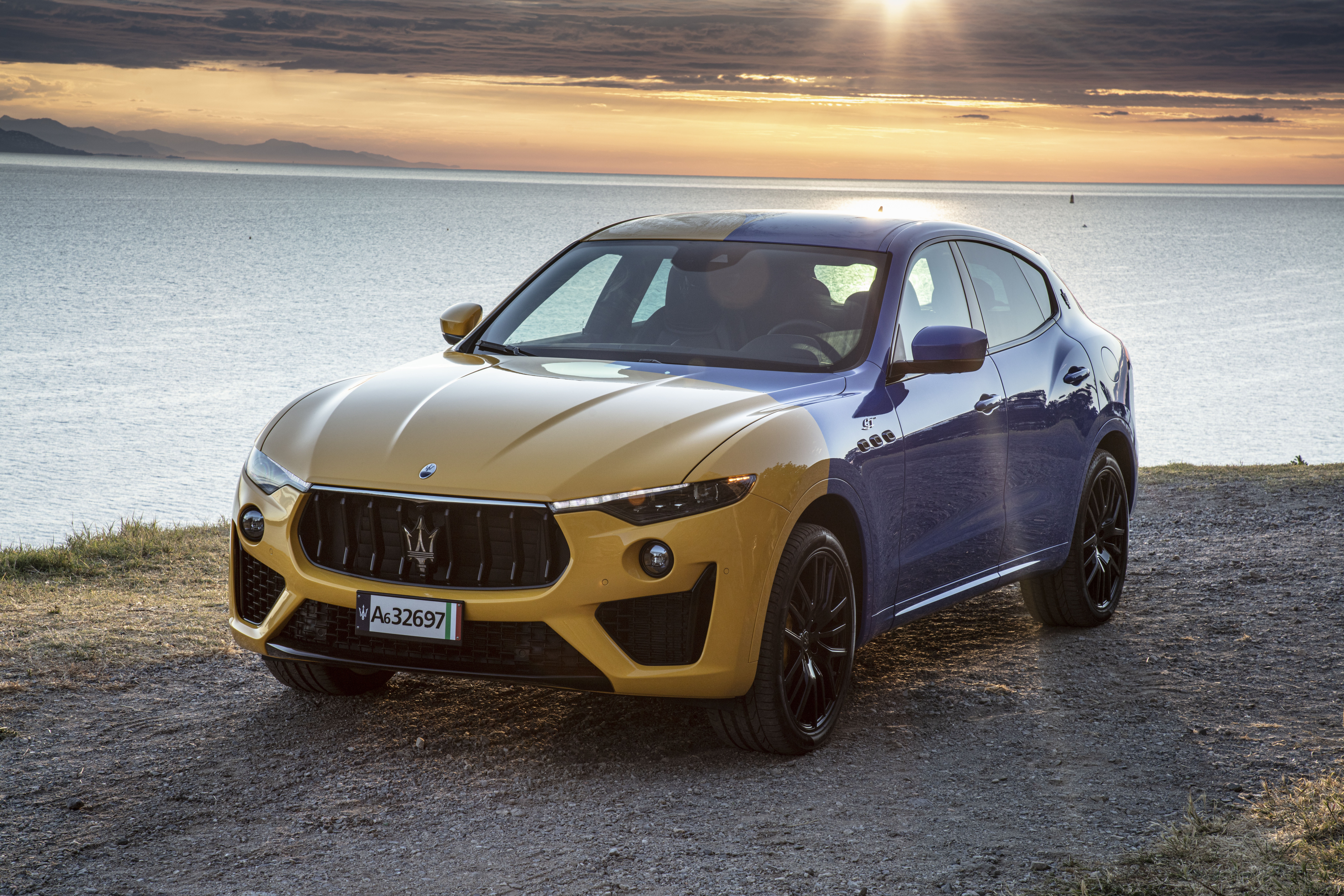 Two-tone Maserati Levante GT Hybrid by the sea at sunset HD Wallpaper