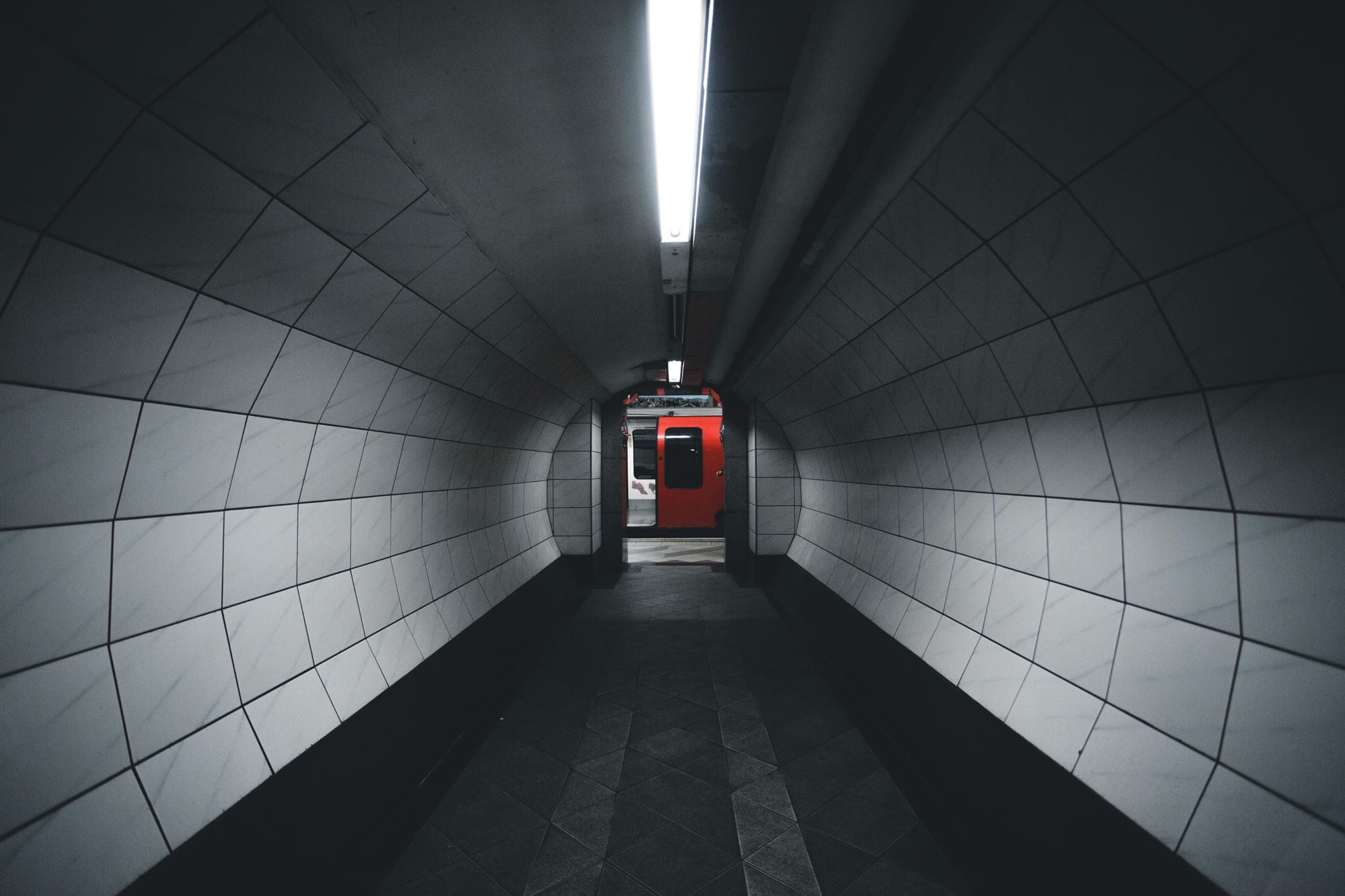 Red train in a dark subway tunnel HD Wallpaper