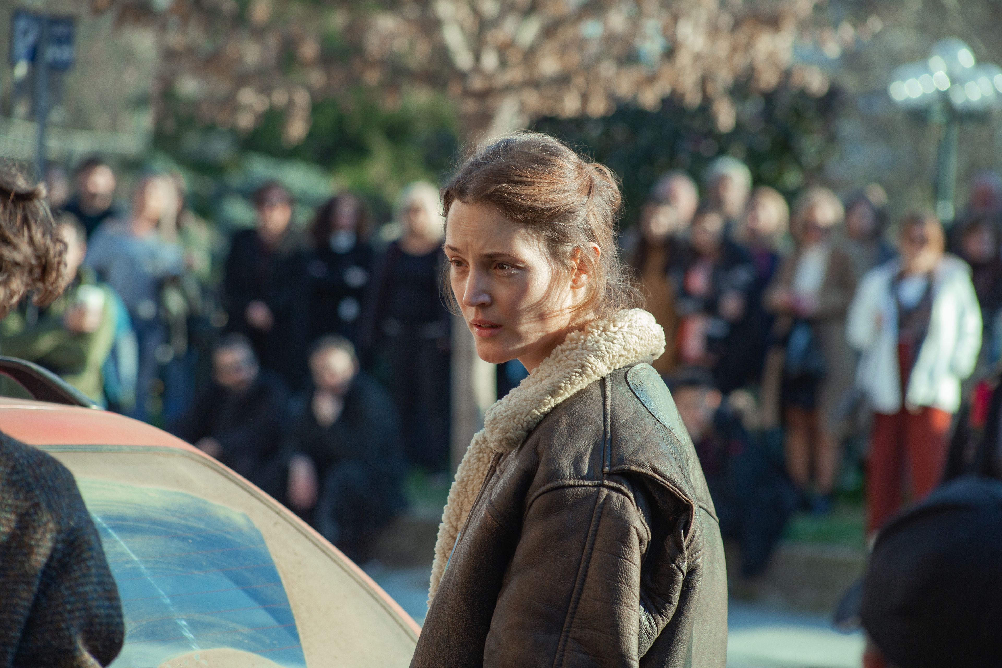 Vicky Krieps in a leather jacket among a crowd HD Wallpaper