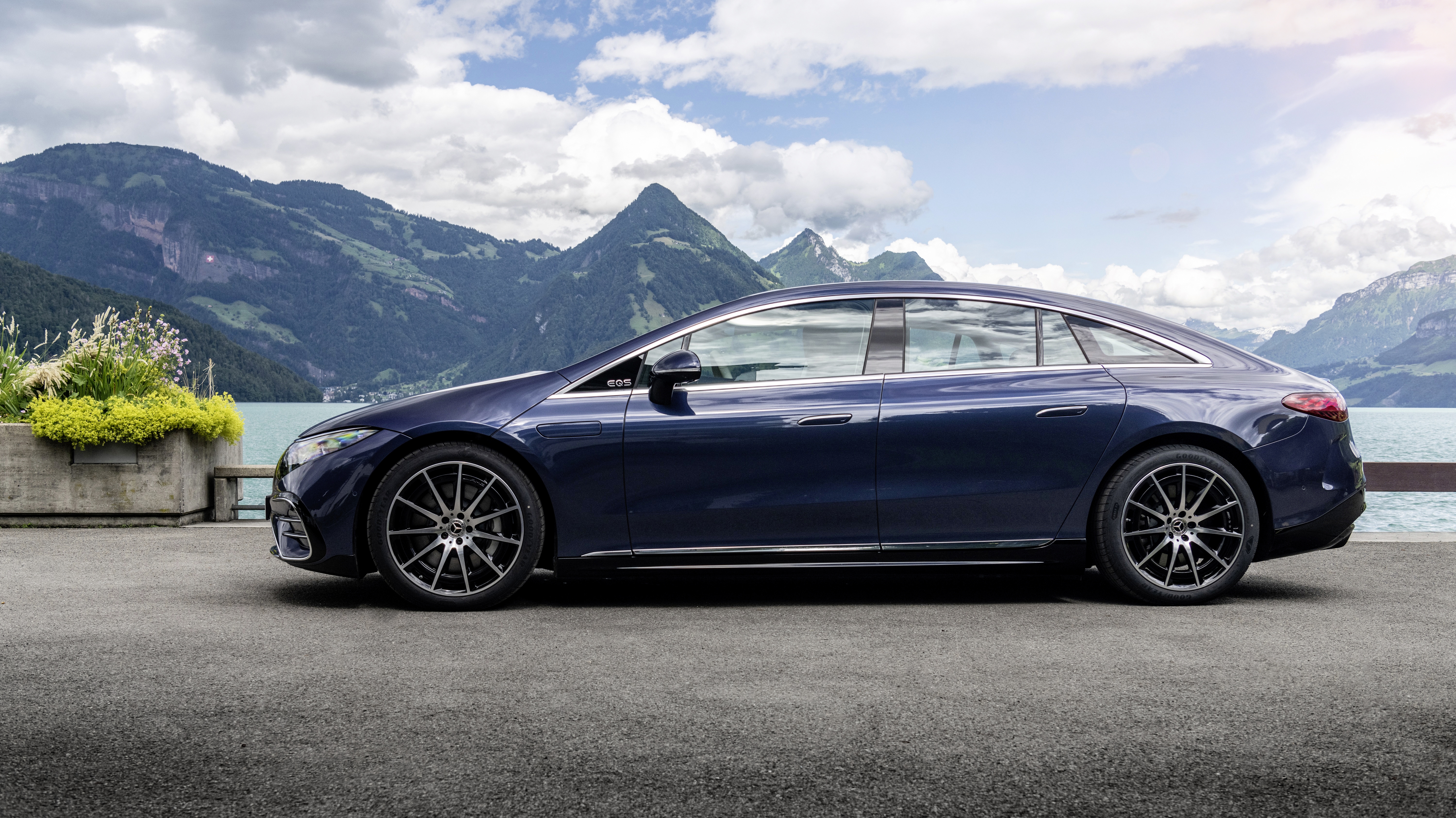 Blue Mercedes-Benz EQS electric luxury car by a mountain lake HD Wallpaper