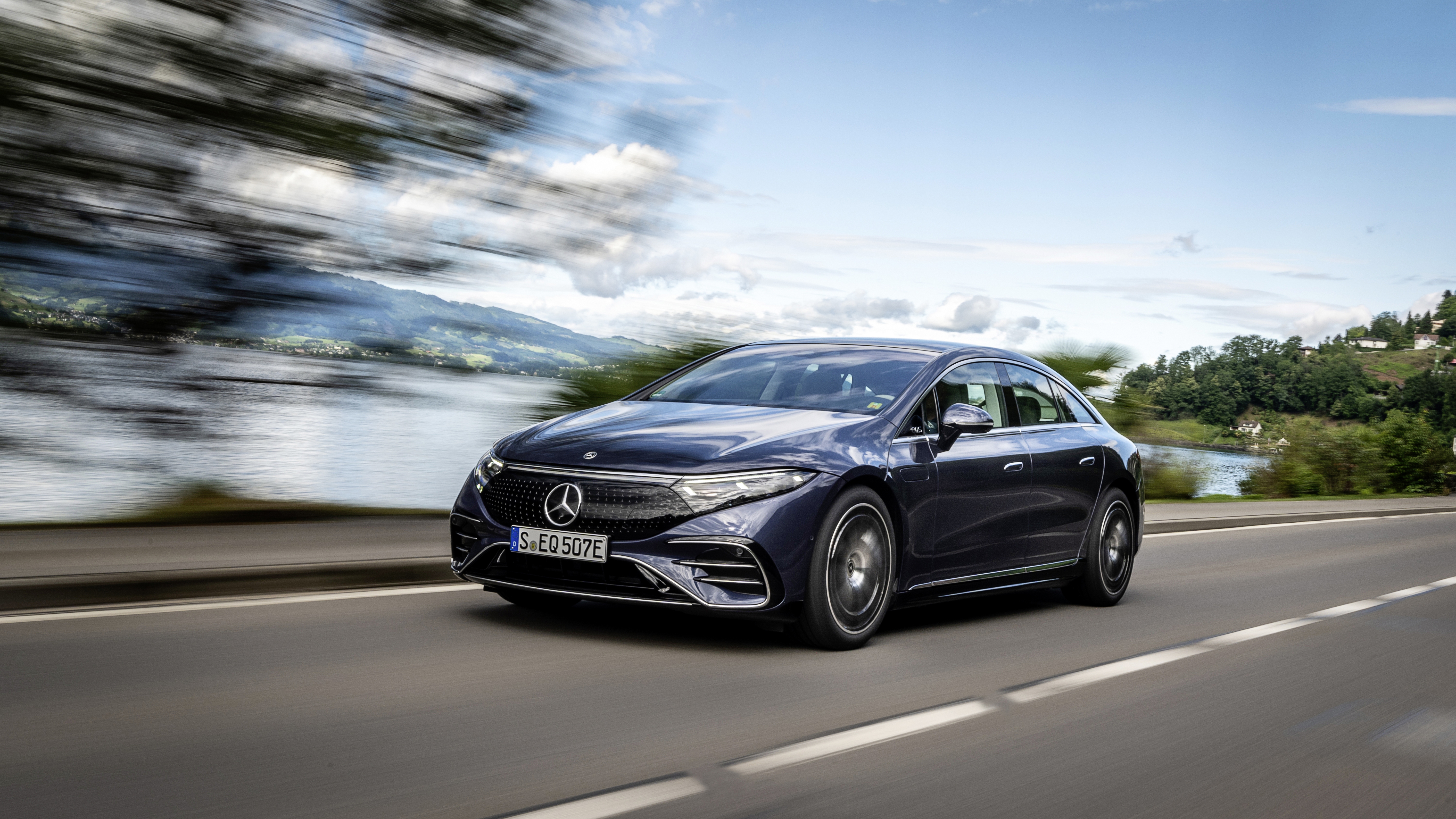 Black Mercedes-Benz EQS electric car driving on scenic road HD Wallpaper