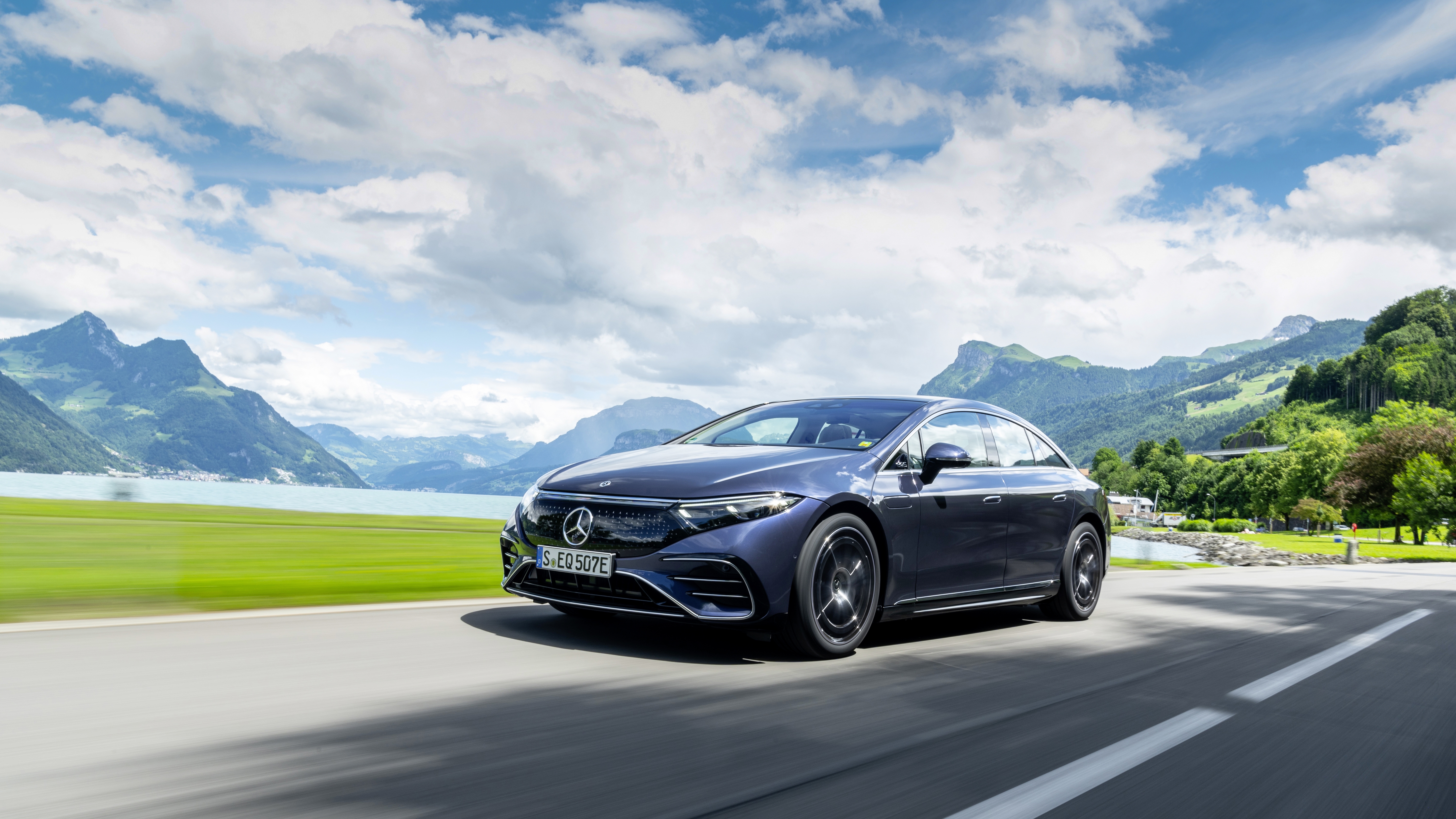 Luxury Mercedes-Benz EQS electric car on a scenic mountain road HD Wallpaper