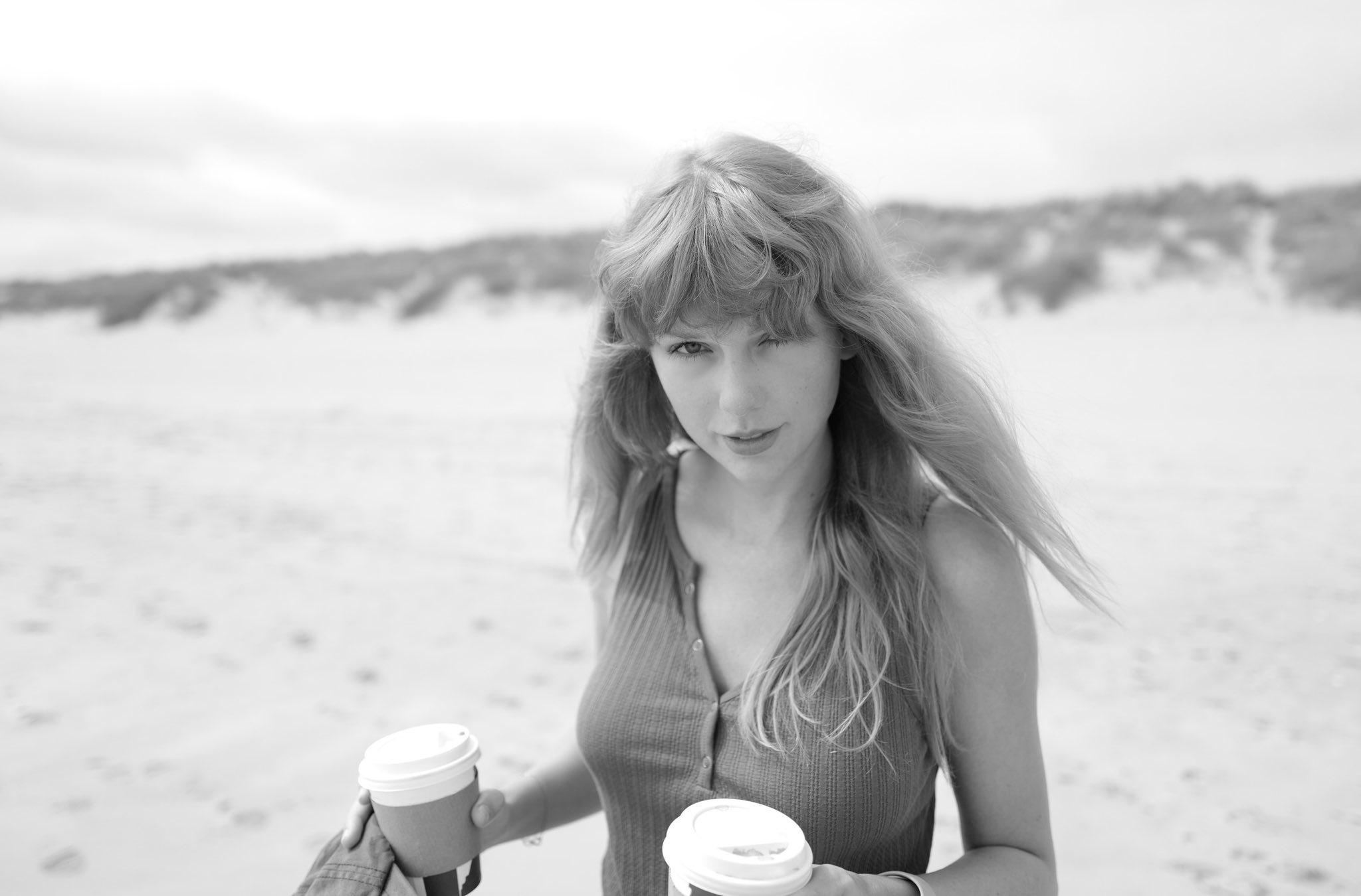 Taylor Swift on the beach holding coffee cups HD Wallpaper