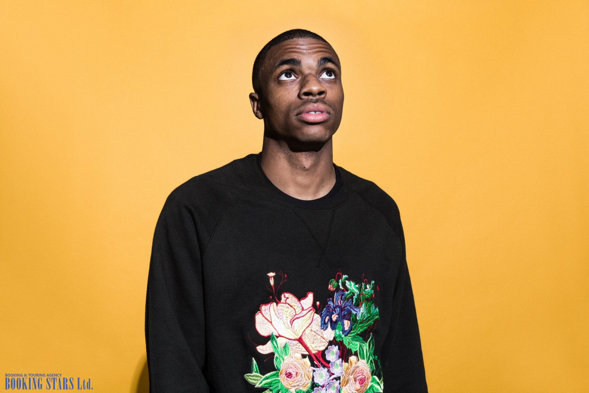 Vince Staples looking up in floral sweatshirt on yellow HD Wallpaper