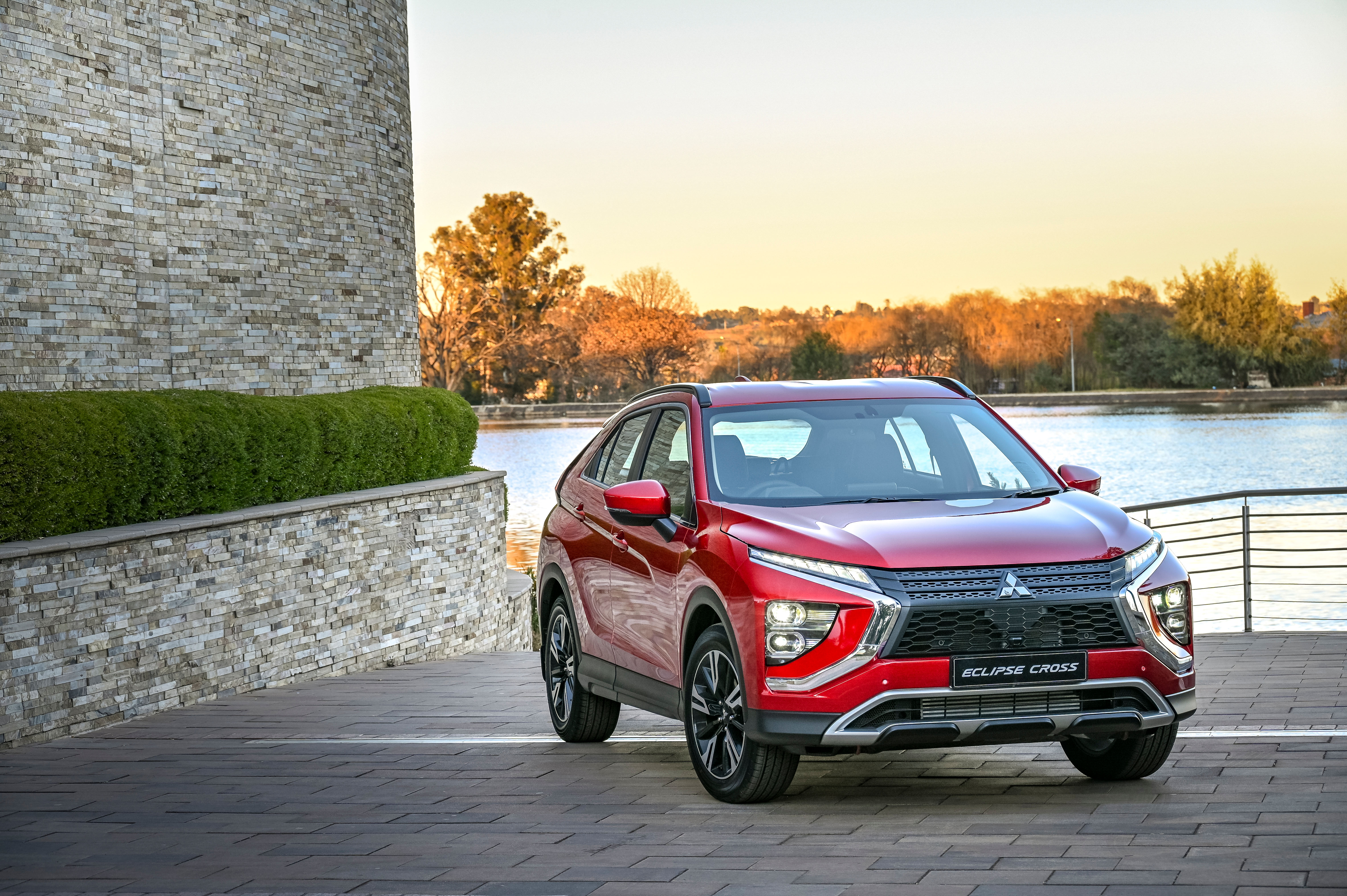 Red Mitsubishi Eclipse Cross SUV by a lake at sunset HD Wallpaper