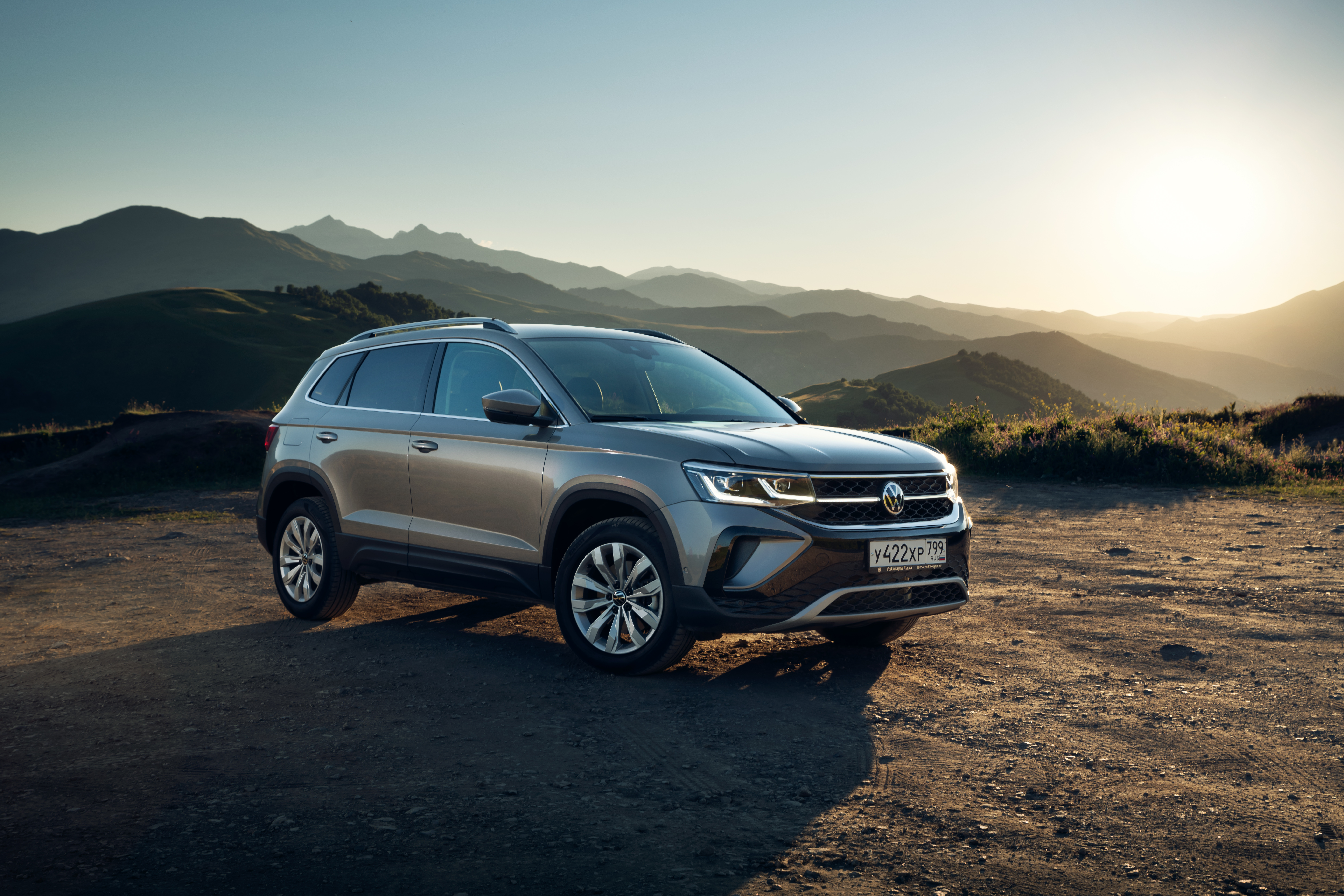 Grey Volkswagen Taos SUV in scenic mountain landscape HD Wallpaper