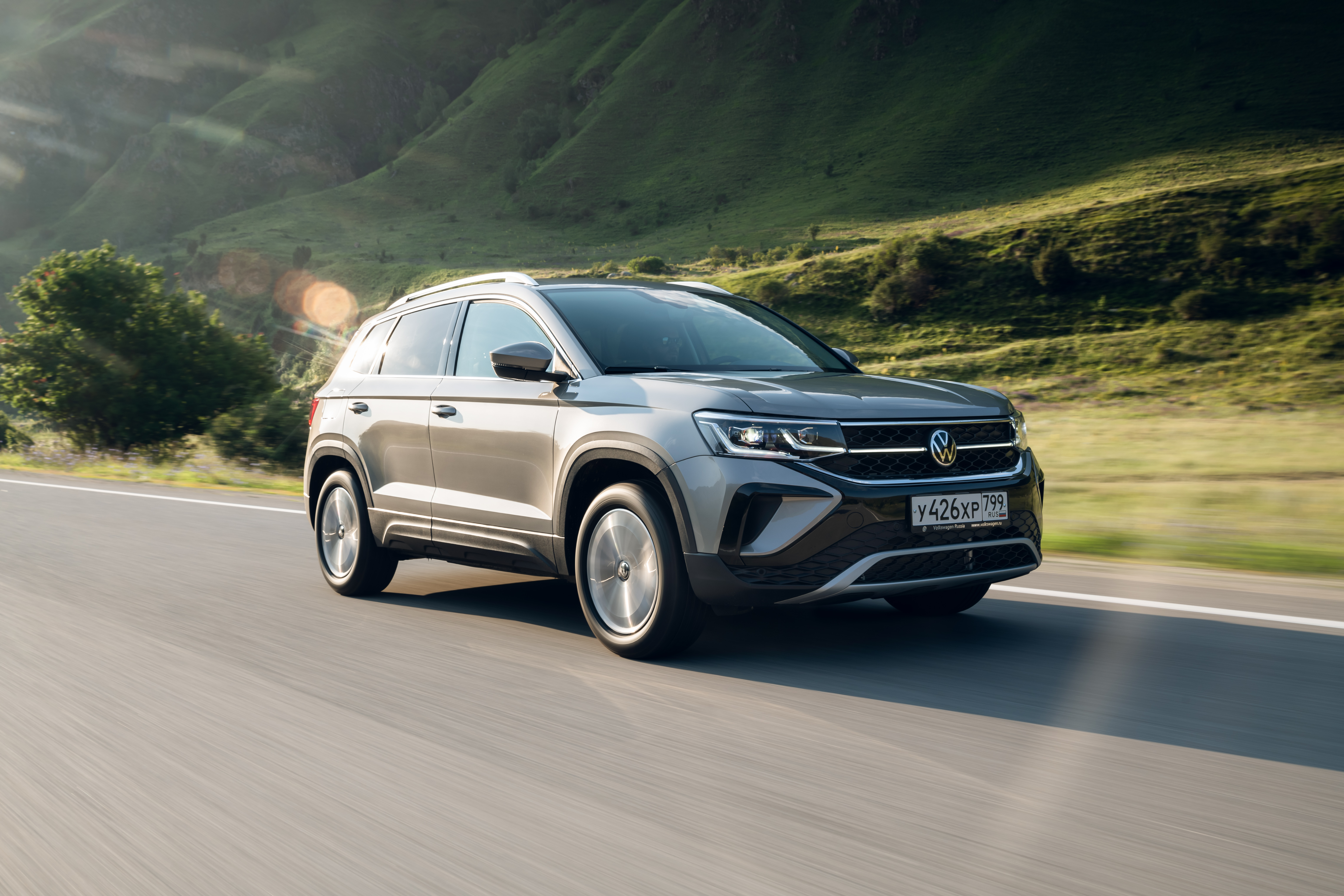 Grey 2021 Volkswagen Taos SUV driving on a mountain road HD Wallpaper