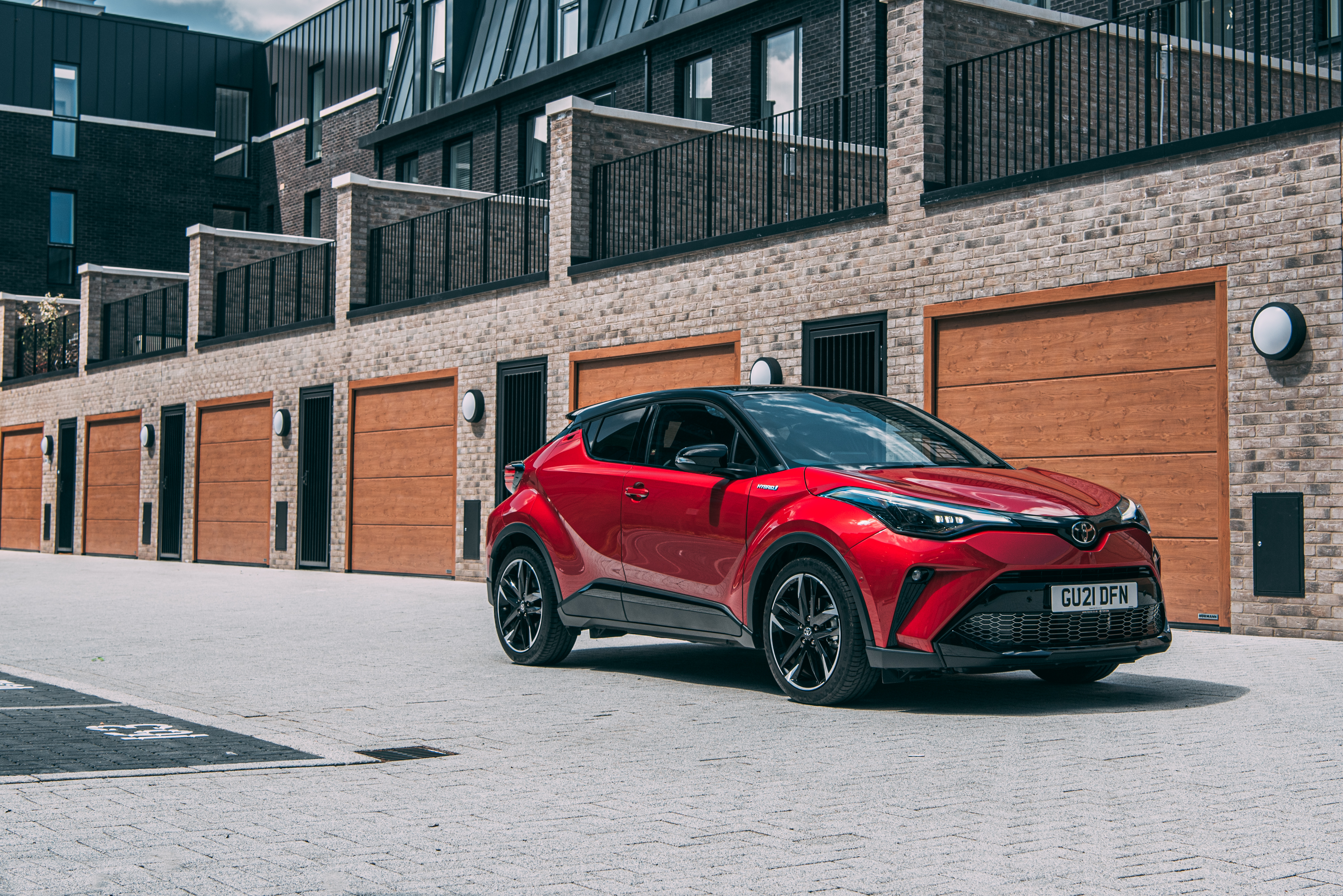 Red Toyota C-HR Hybrid GR Sport SUV by modern buildings HD Wallpaper