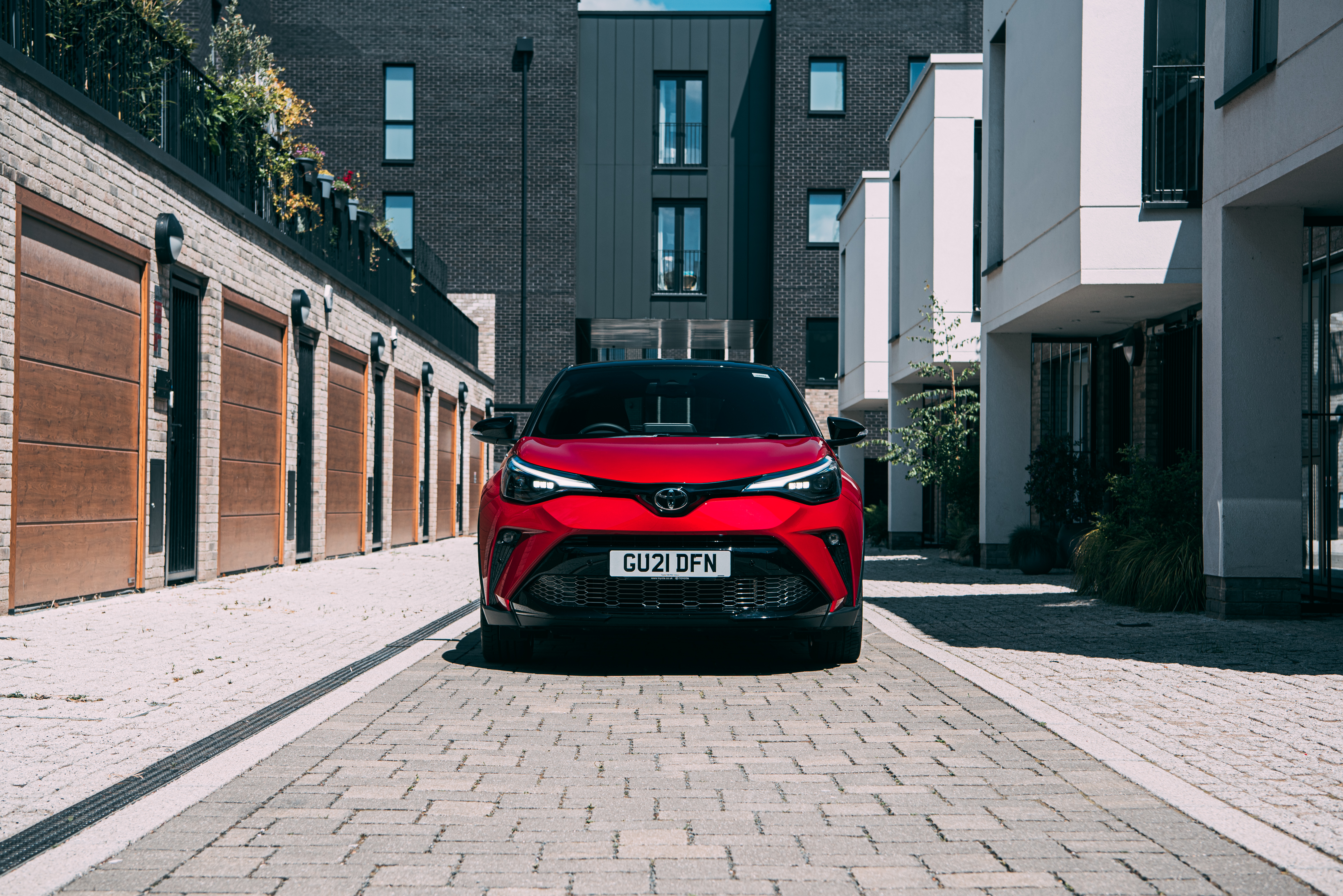 Red Toyota C-HR Hybrid GR Sport SUV on urban street HD Wallpaper