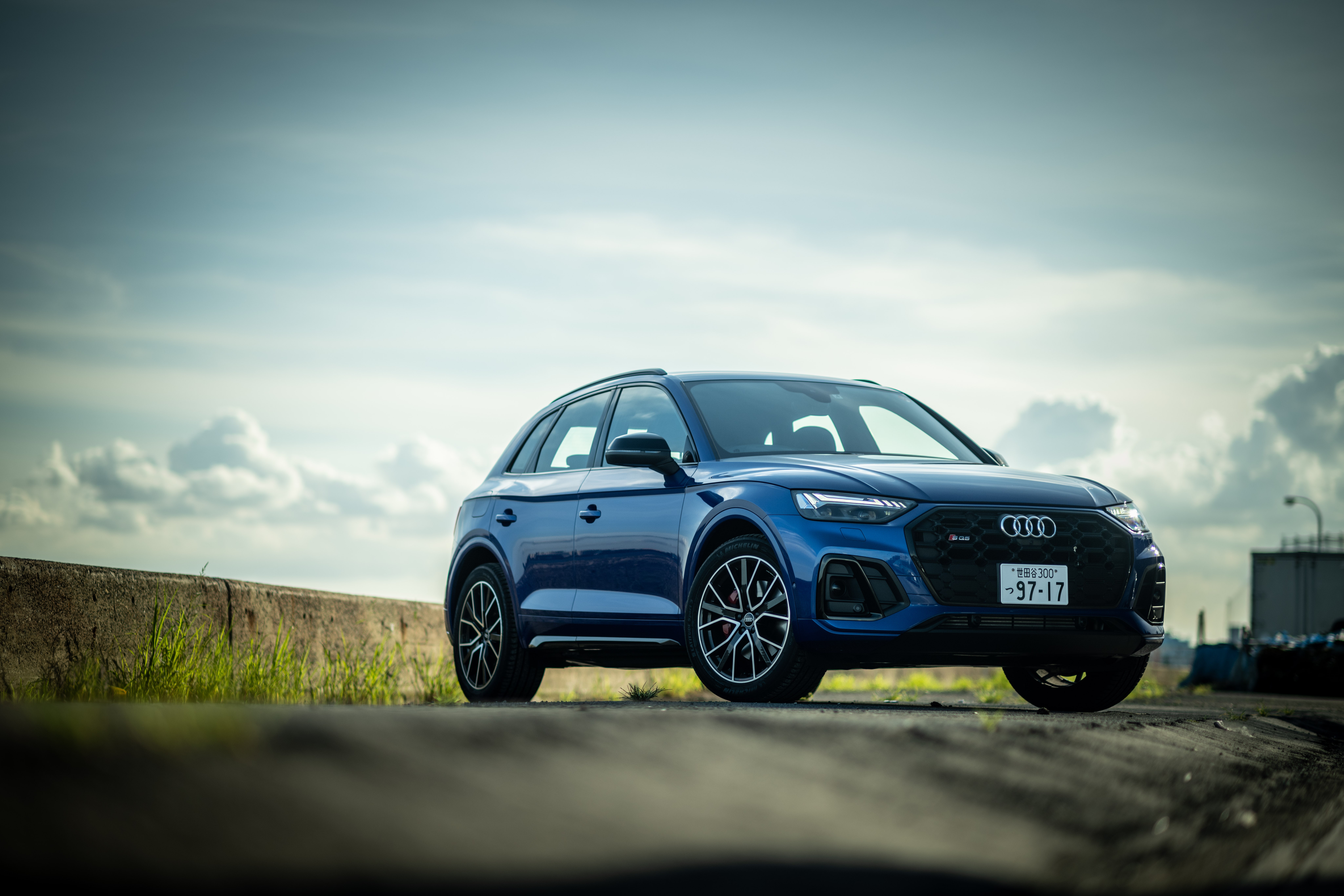 Blue Audi SQ5 SUV under cloudy sky HD Wallpaper