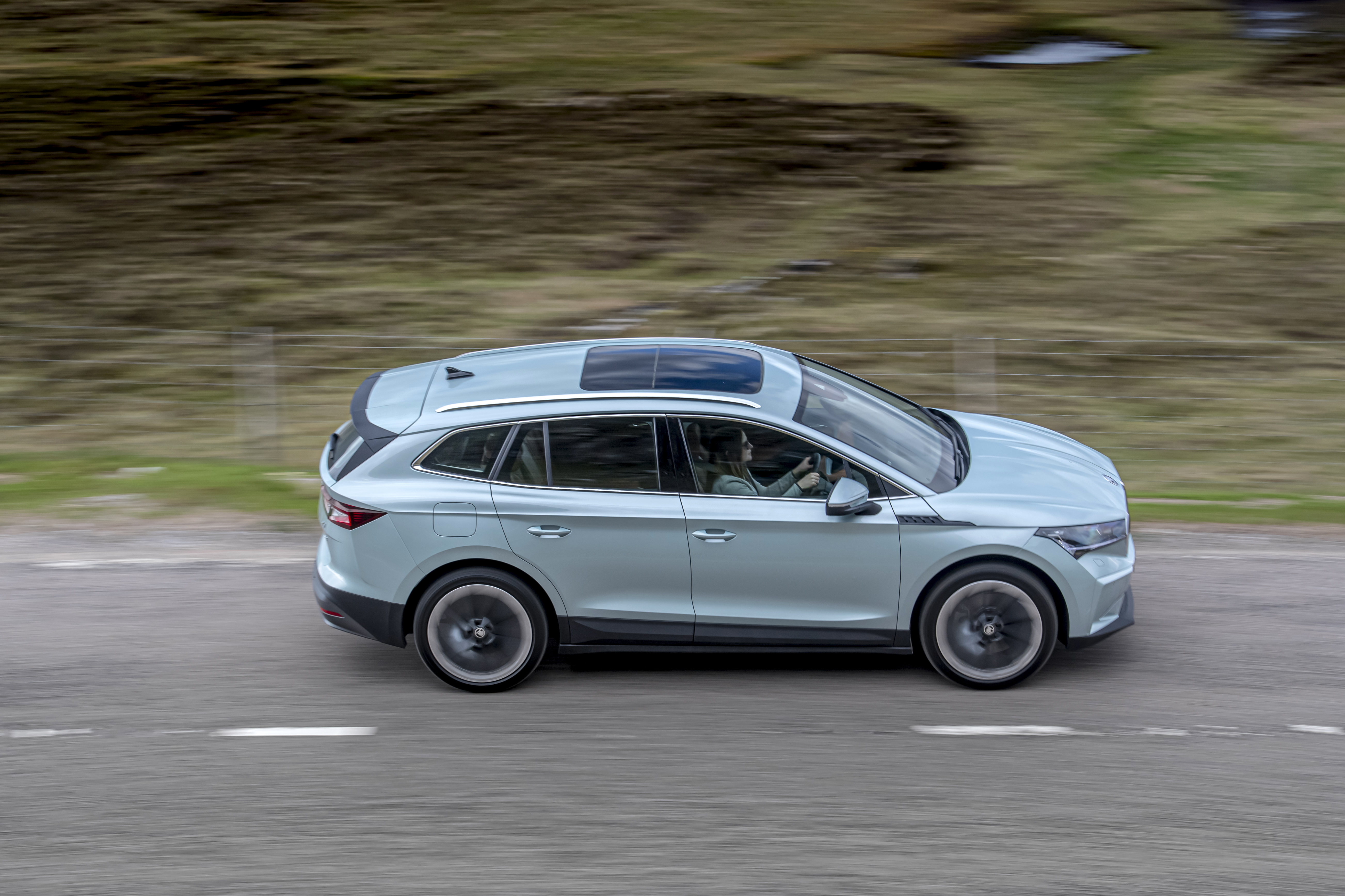 Škoda Enyaq Electric SUV driving on road HD Wallpaper