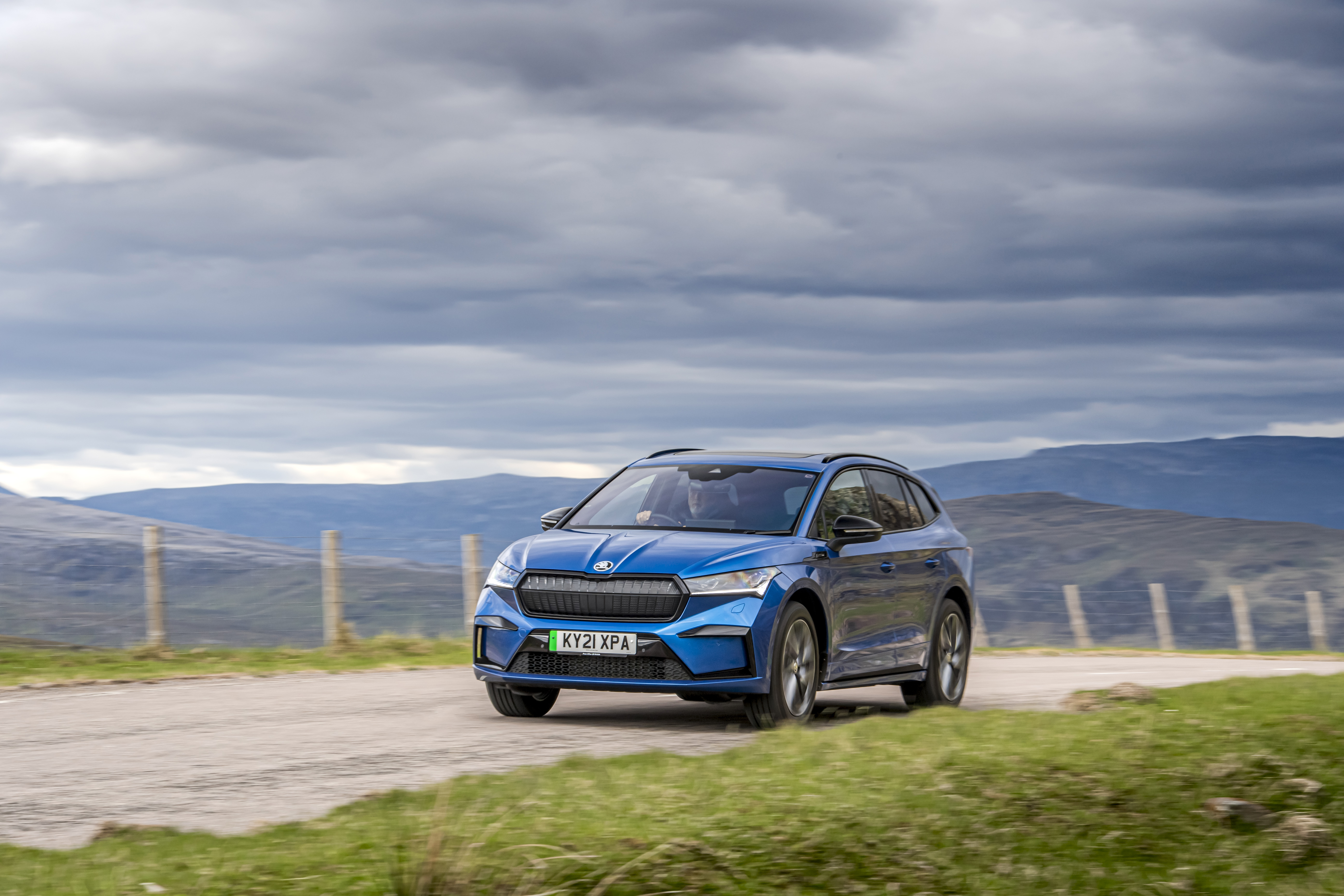 Blue Škoda Enyaq electric SUV on a cloudy mountain road HD Wallpaper