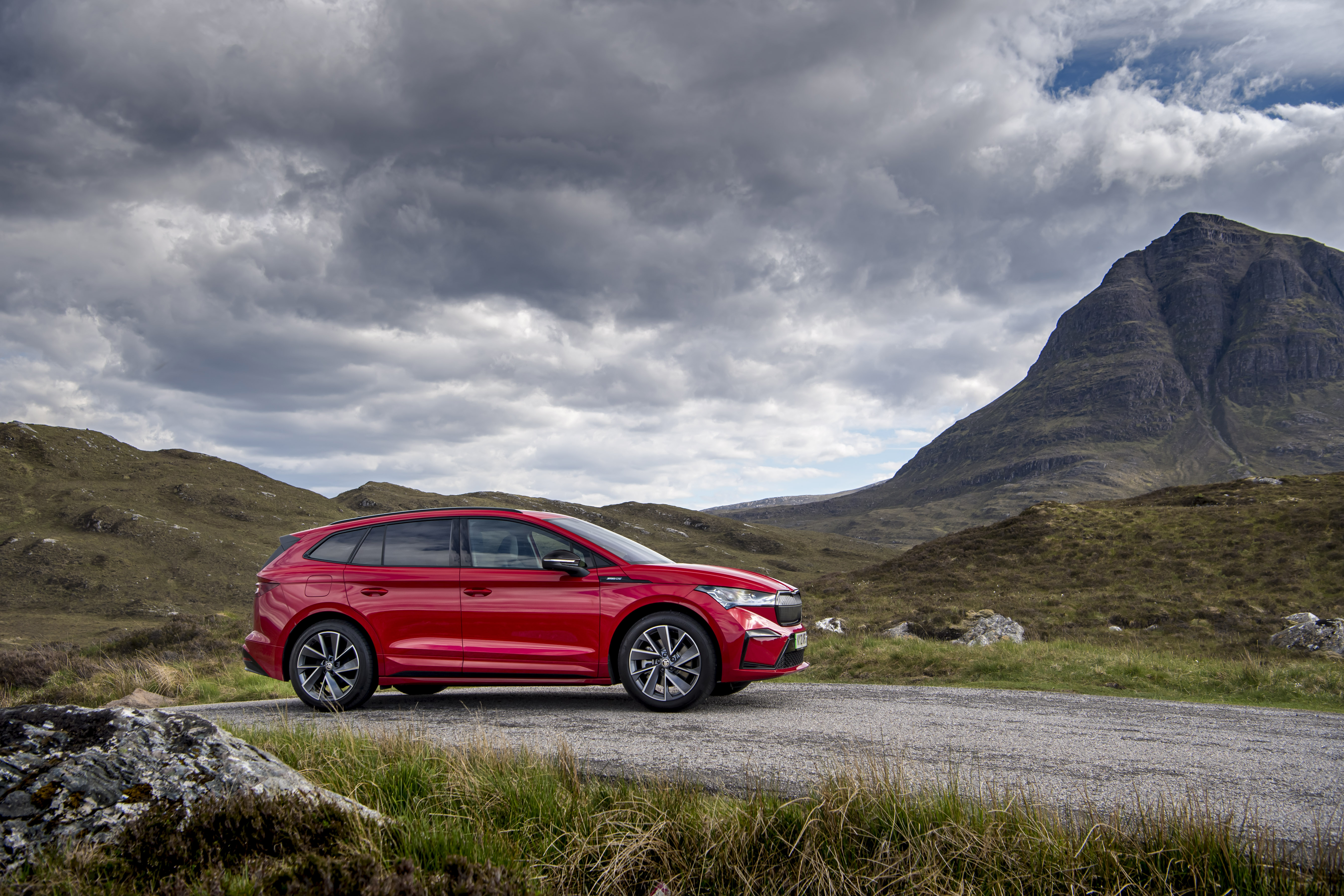 Red Škoda Enyaq electric SUV on a mountain road HD Wallpaper