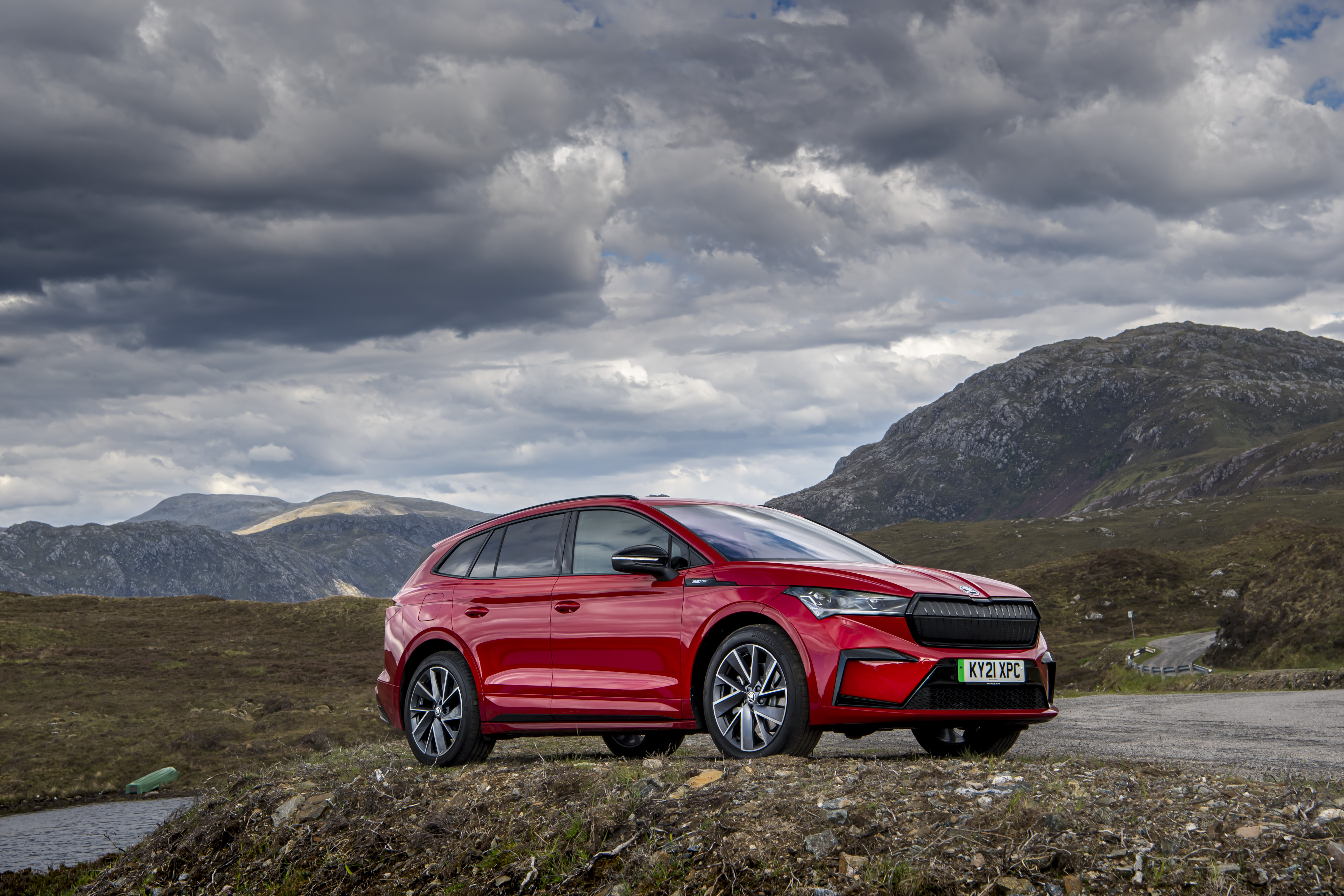 Red Škoda Enyaq electric SUV in mountains HD Wallpaper