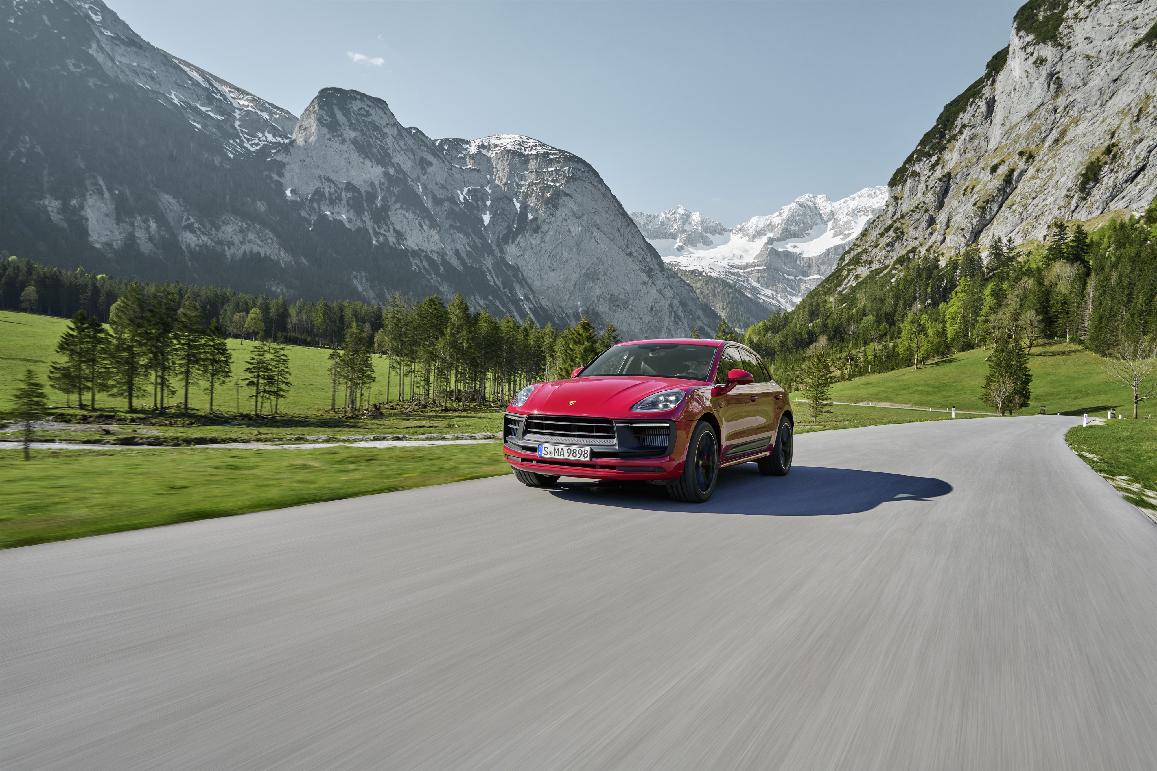 Red Porsche Macan GTS SUV on a scenic mountain road HD Wallpaper