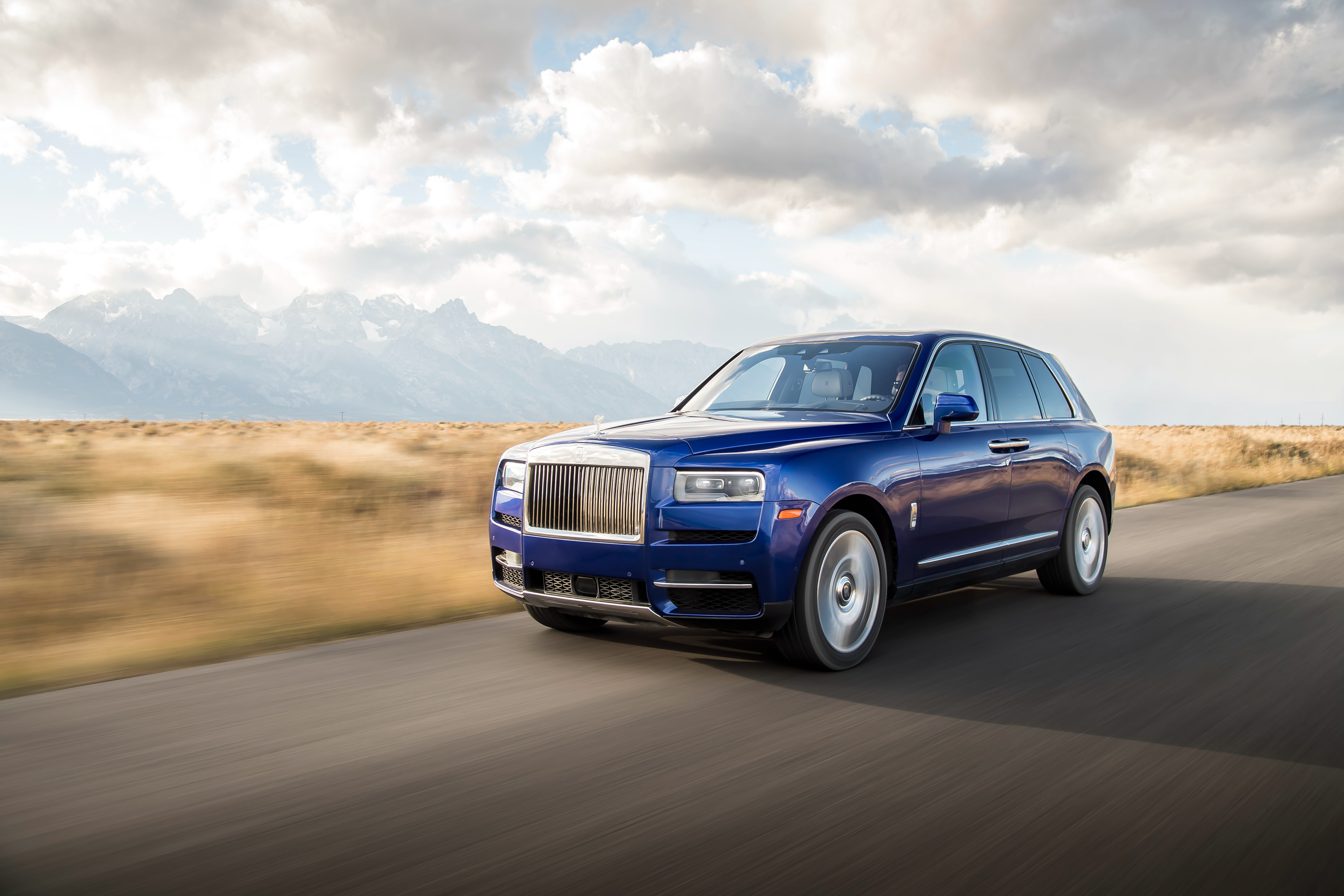 Rolls-Royce Cullinan SUV driving on a mountain road HD Wallpaper