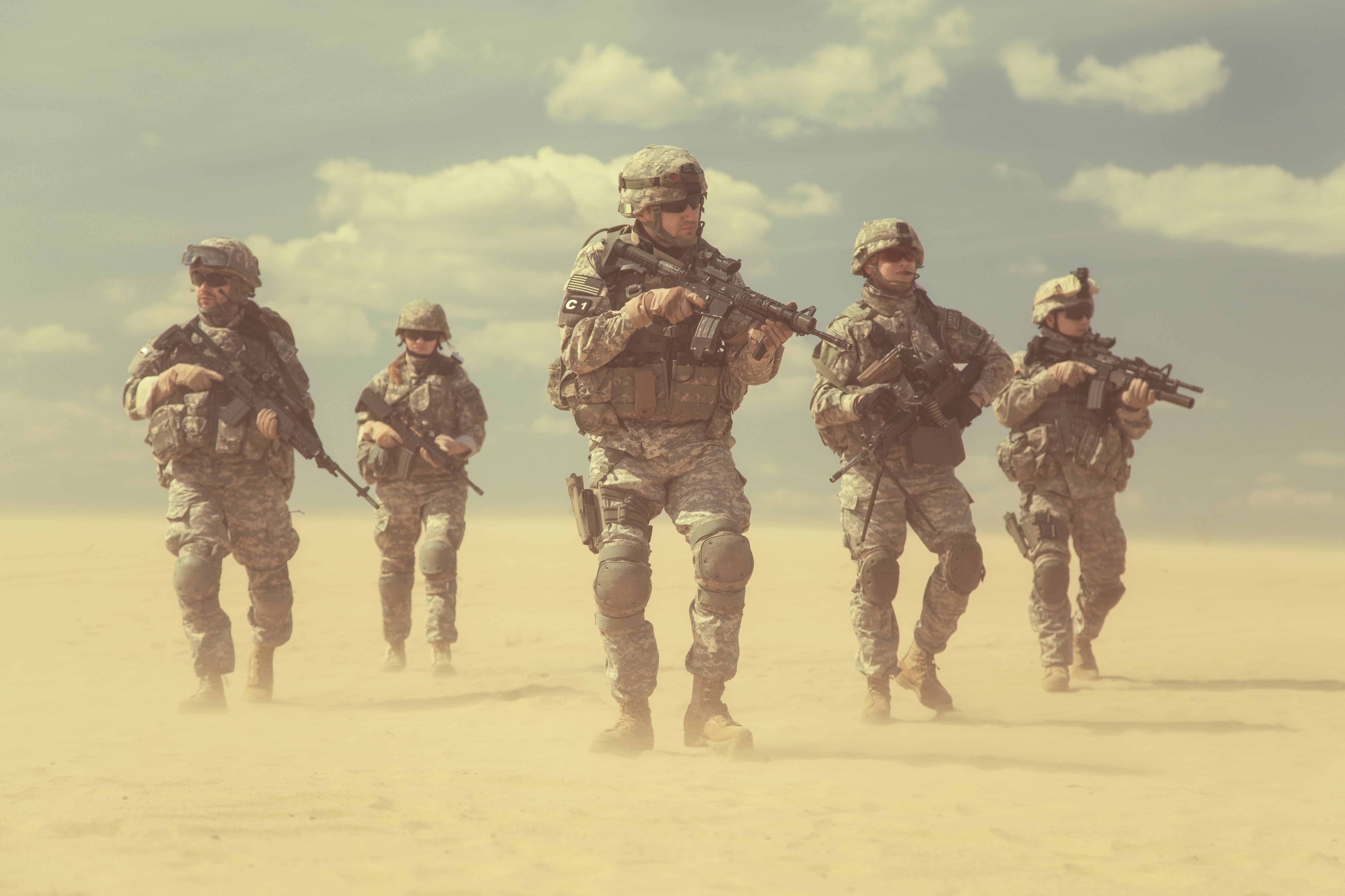 Soldiers walking through a dusty desert HD Wallpaper