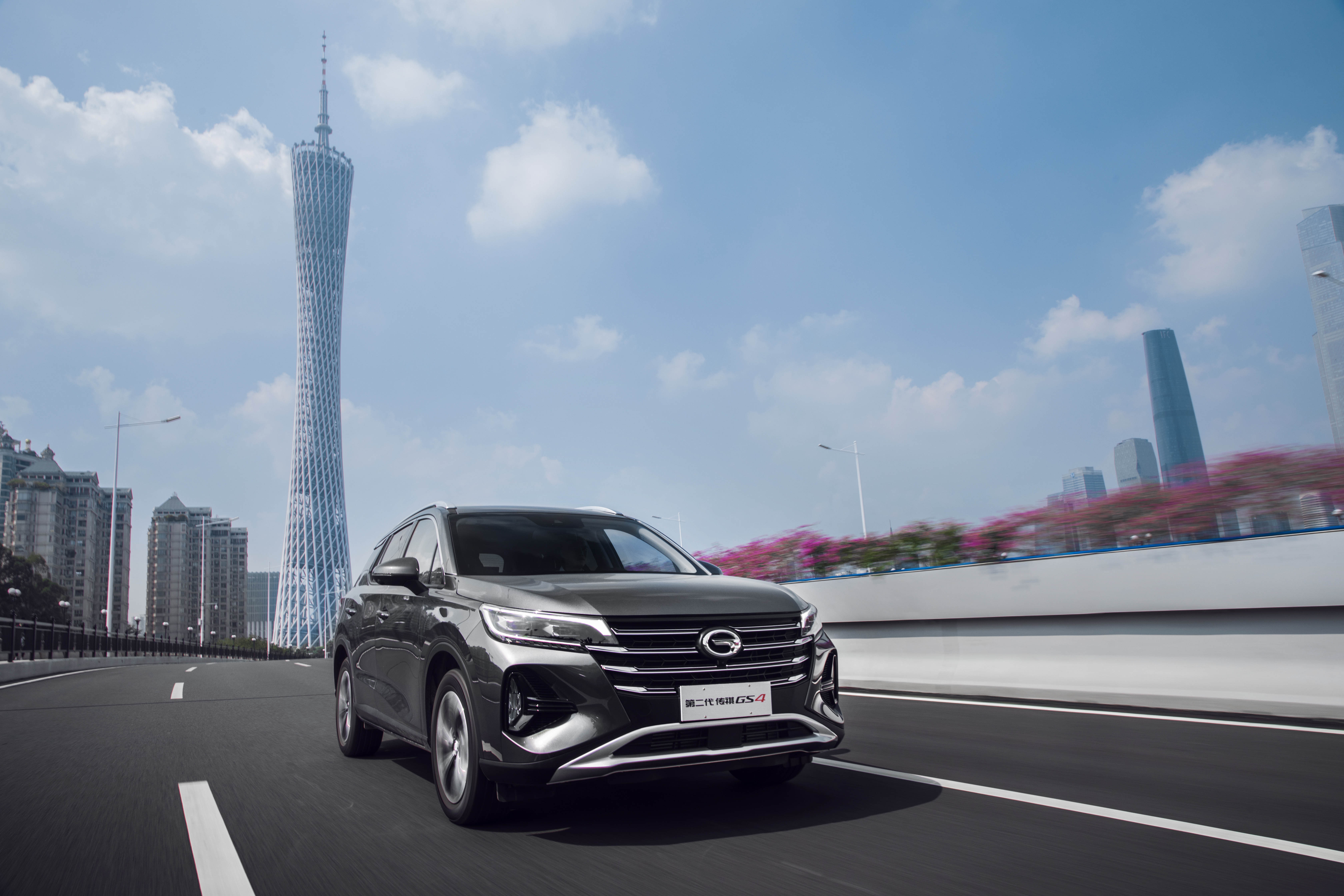 Grey Trumpchi GS4 SUV driving past Canton Tower HD Wallpaper