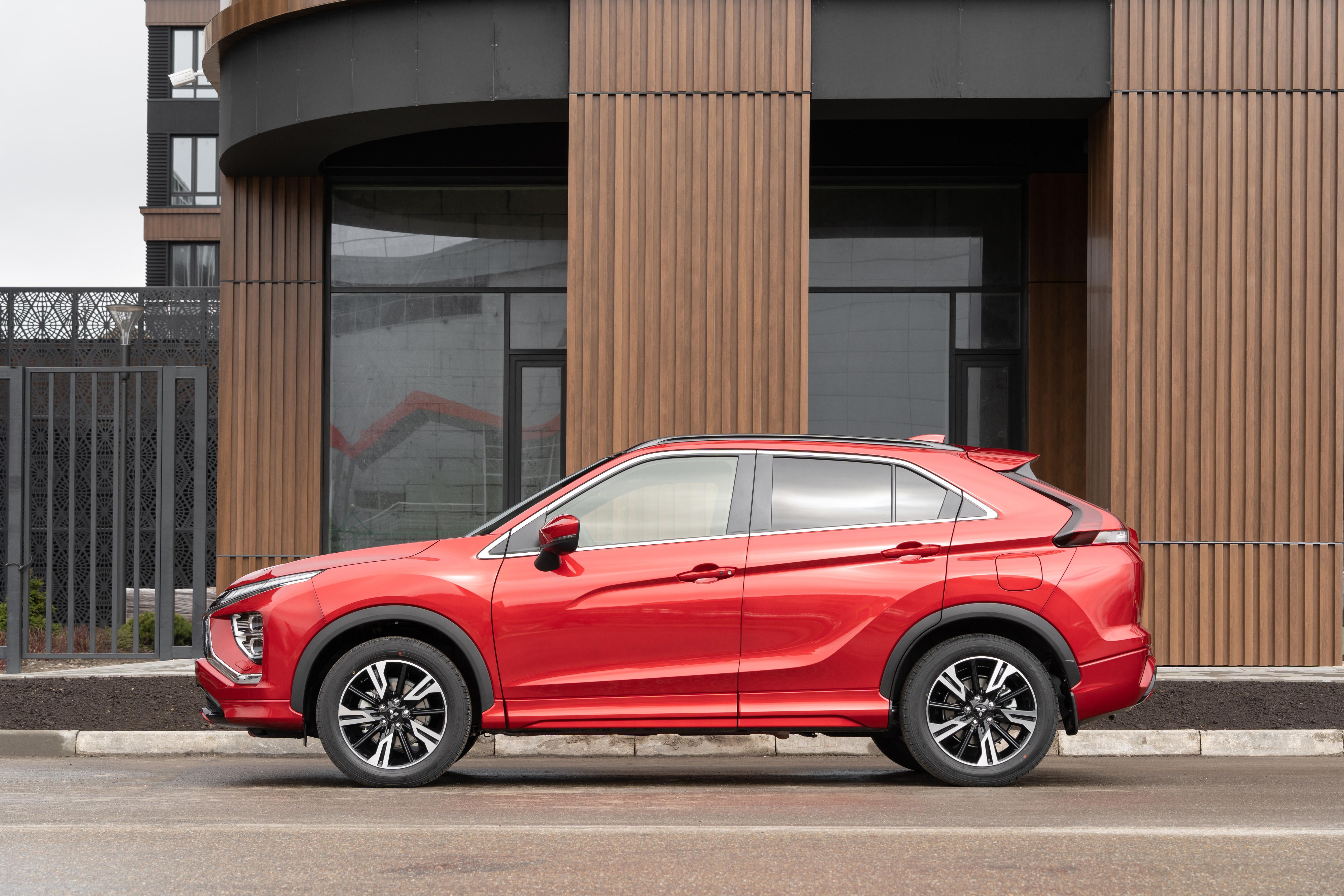 Red Mitsubishi Eclipse Cross SUV parked by modern building HD Wallpaper